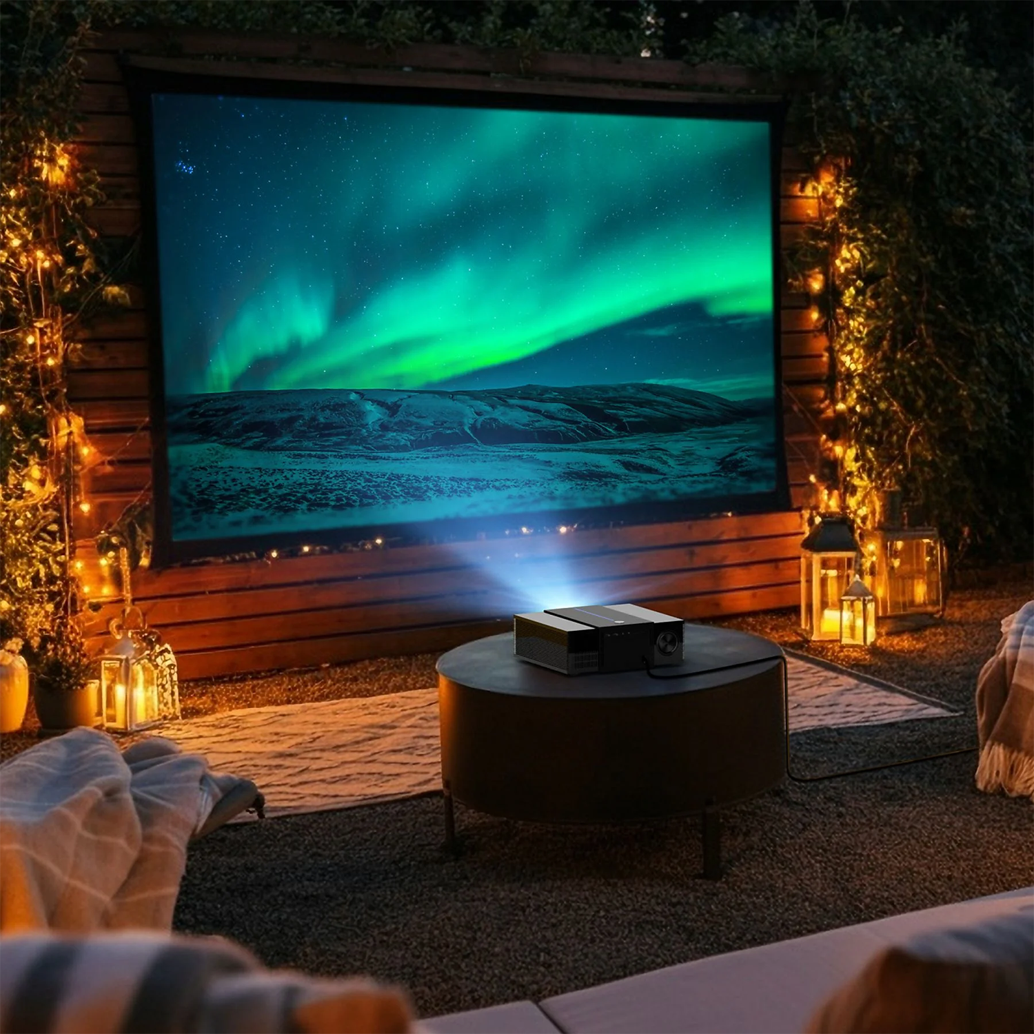 Proyector exterior muestra aurora en pantalla, iluminado por luces y faroles.