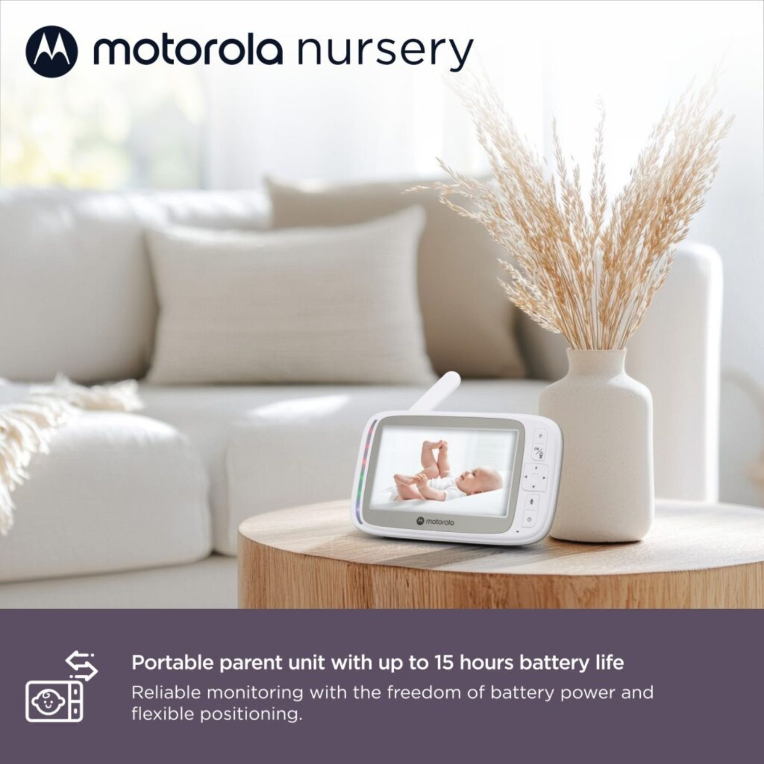 Motorola Babyphone auf einem Holztisch vor einem Sofa. Zeigt Baby.
