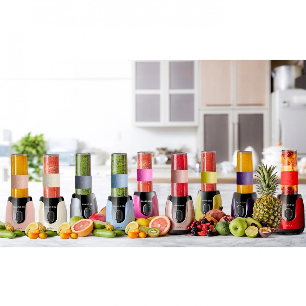 Mutfak ortamında renkli smoothie bardakları ve taze meyvelerle birden fazla blender.