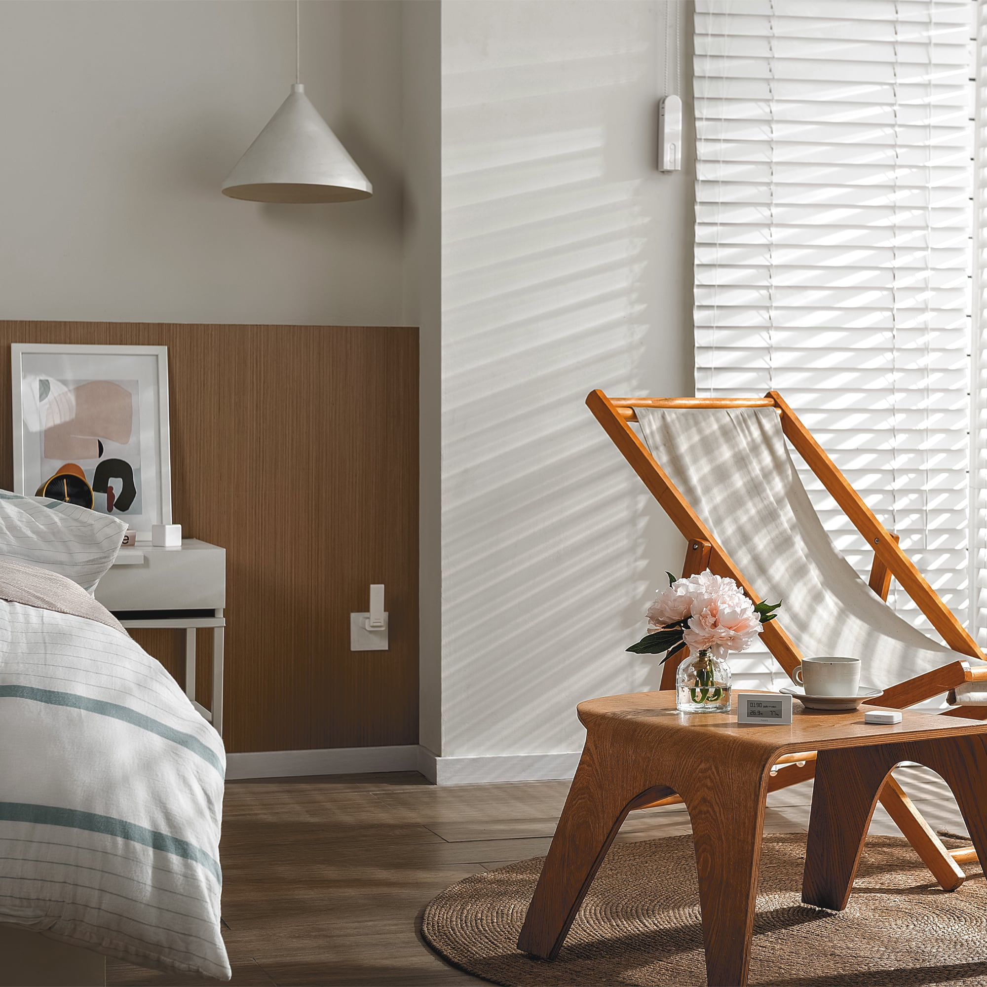 Un dormitorio con cama, mesita de noche, tumbona y flores.