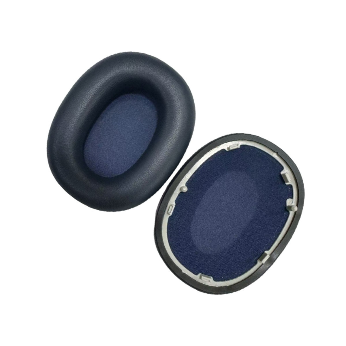 Due cuscinetti auricolari per cuffie in tessuto blu scuro e finta pelle nera.