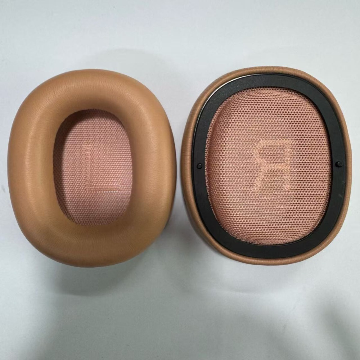 Zwei Ohrpolster für Kopfhörer, beige und rosafarben, auf weißem Hintergrund.