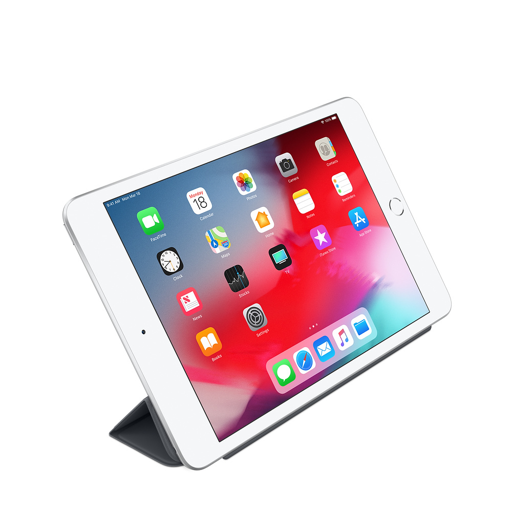 Een witte iPad met een donkere standaard toont het startscherm.