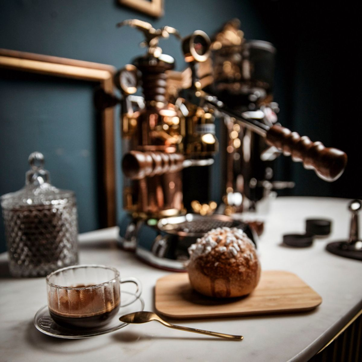 Filiżanka espresso z kawą, ciastko i ekspres do kawy.