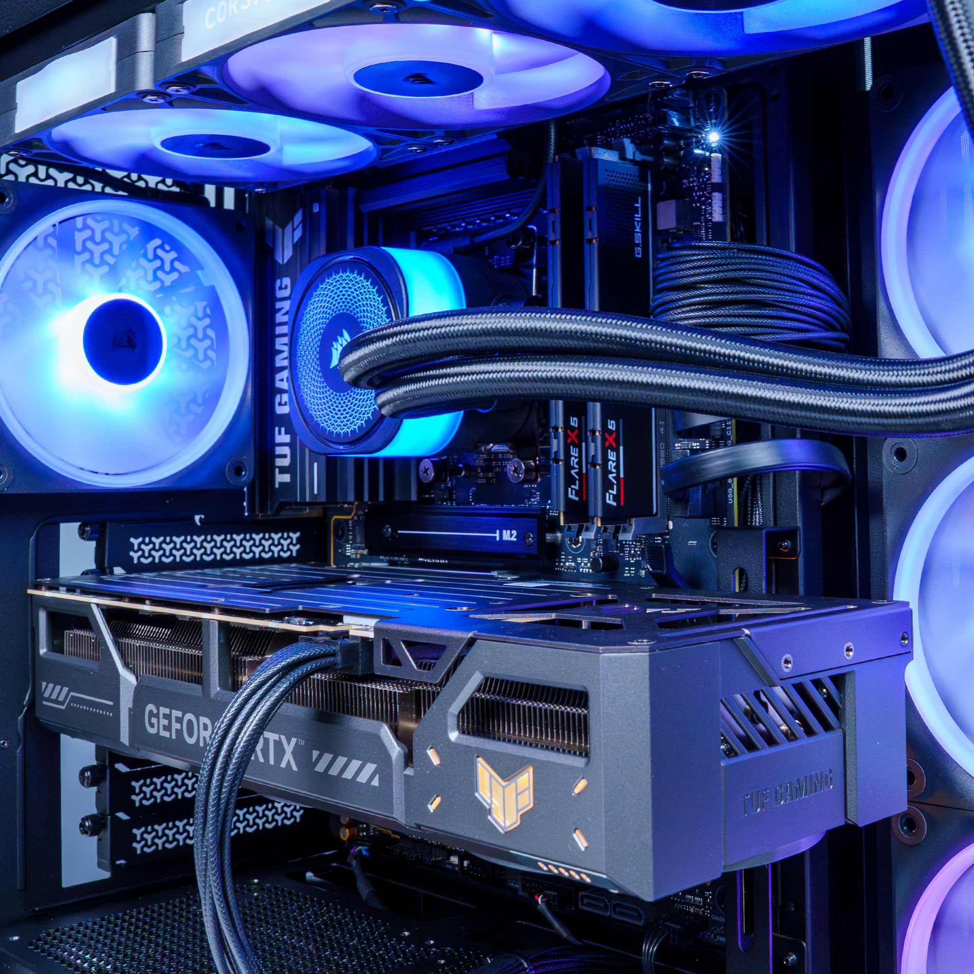 Una caja de PC abierta con LEDs azules. Tarjeta gráfica, ventiladores y cables visibles.