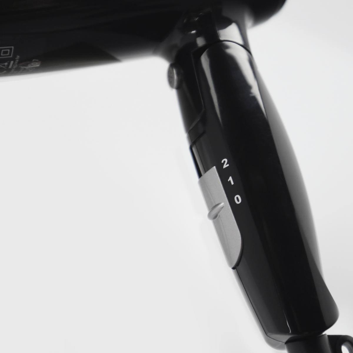 Zbliżenie czarnej suszarki do włosów z przełącznikiem 0, 1 i 2.