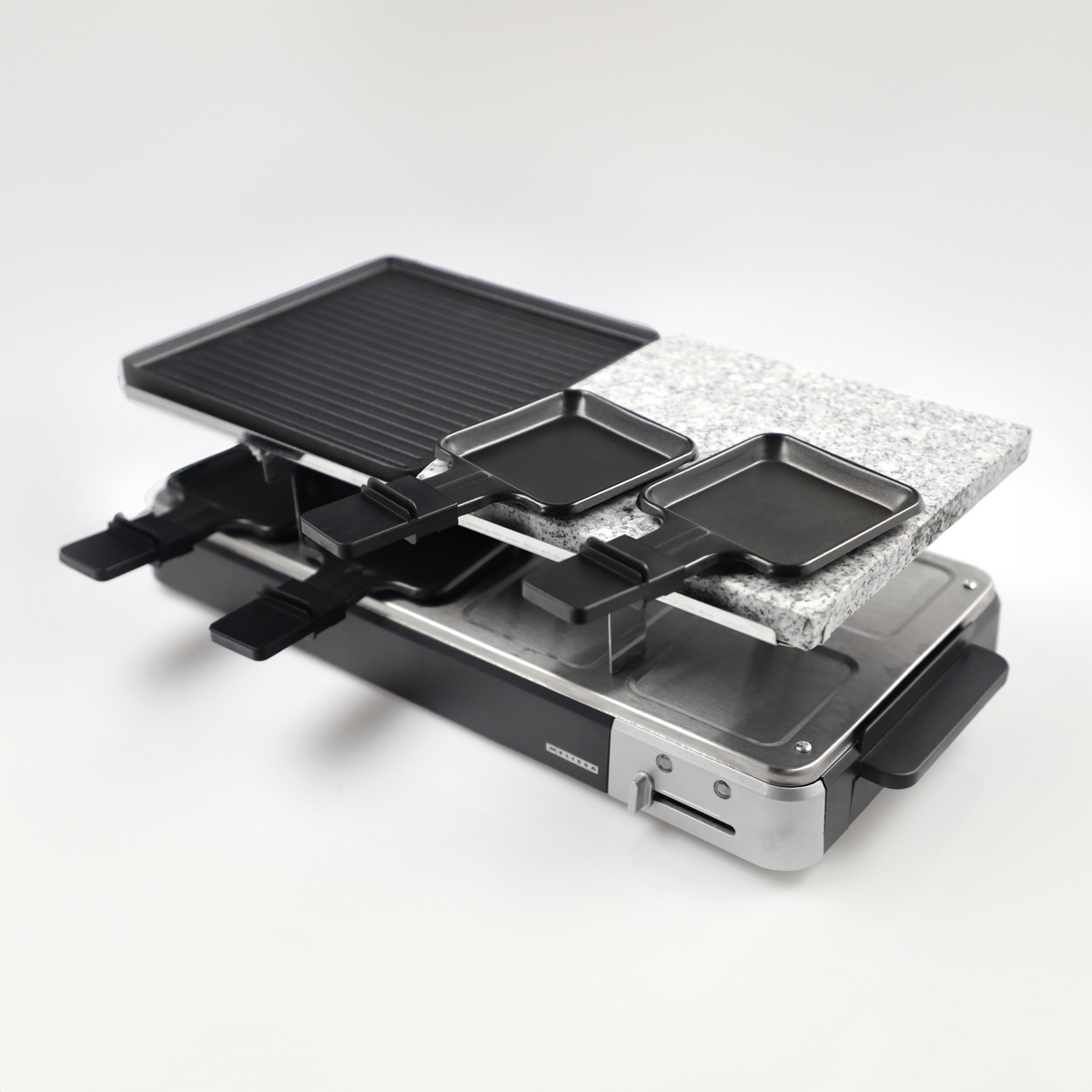 Grill do raclette z płytą grillową, kamienną i patelniami na podstawie ze stali nierdzewnej.