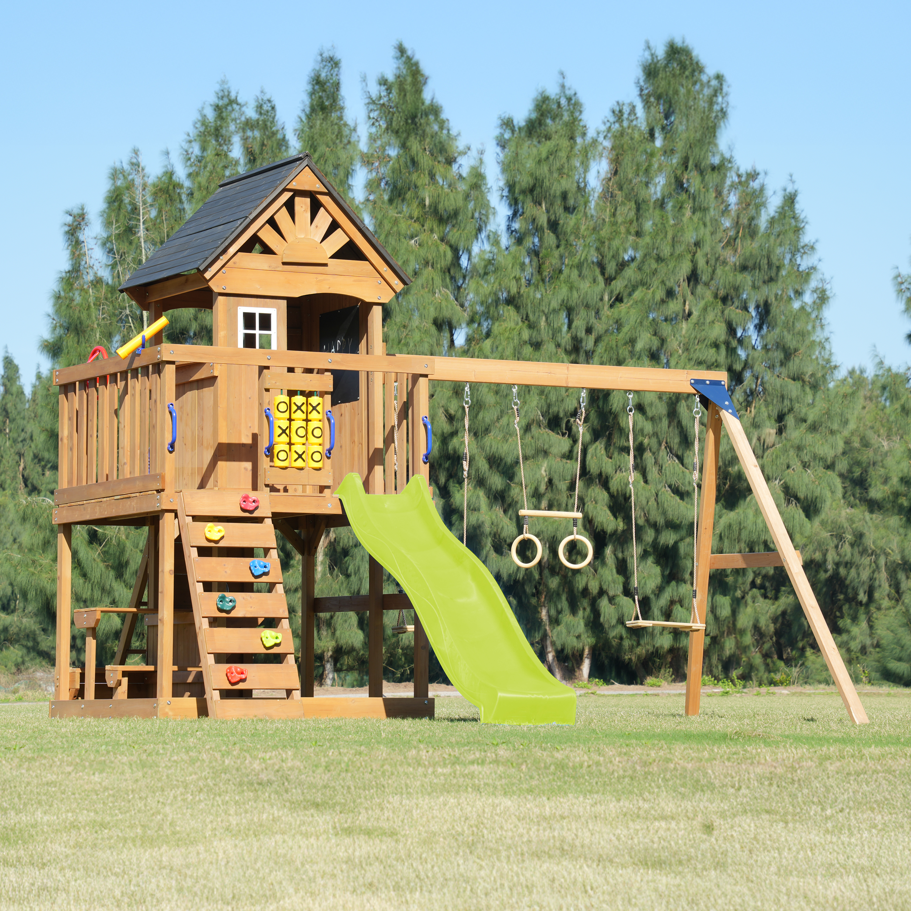 Ein hölzerner Spielturm mit Rutsche, Schaukeln und Kletterwand im Freien.