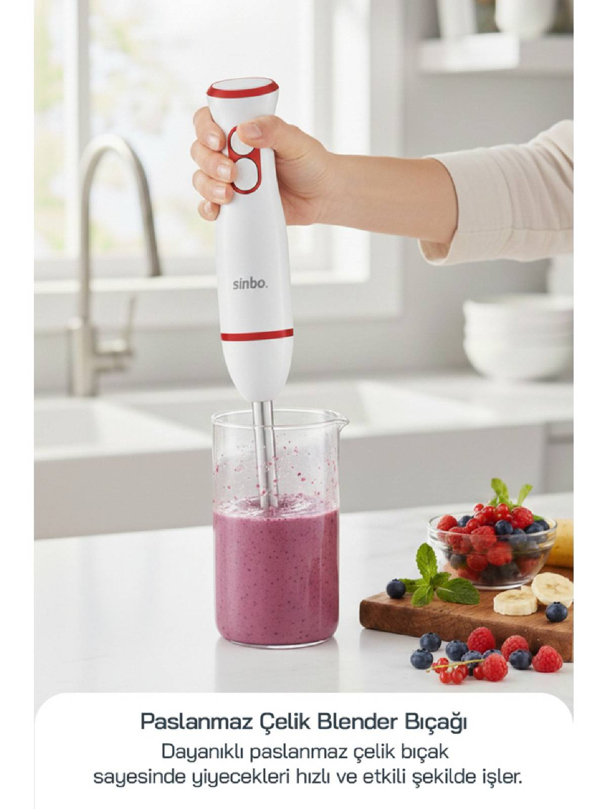 Bir el, smoothie bardağının üzerinde beyaz ve kırmızı daldırma blender tutuyor.