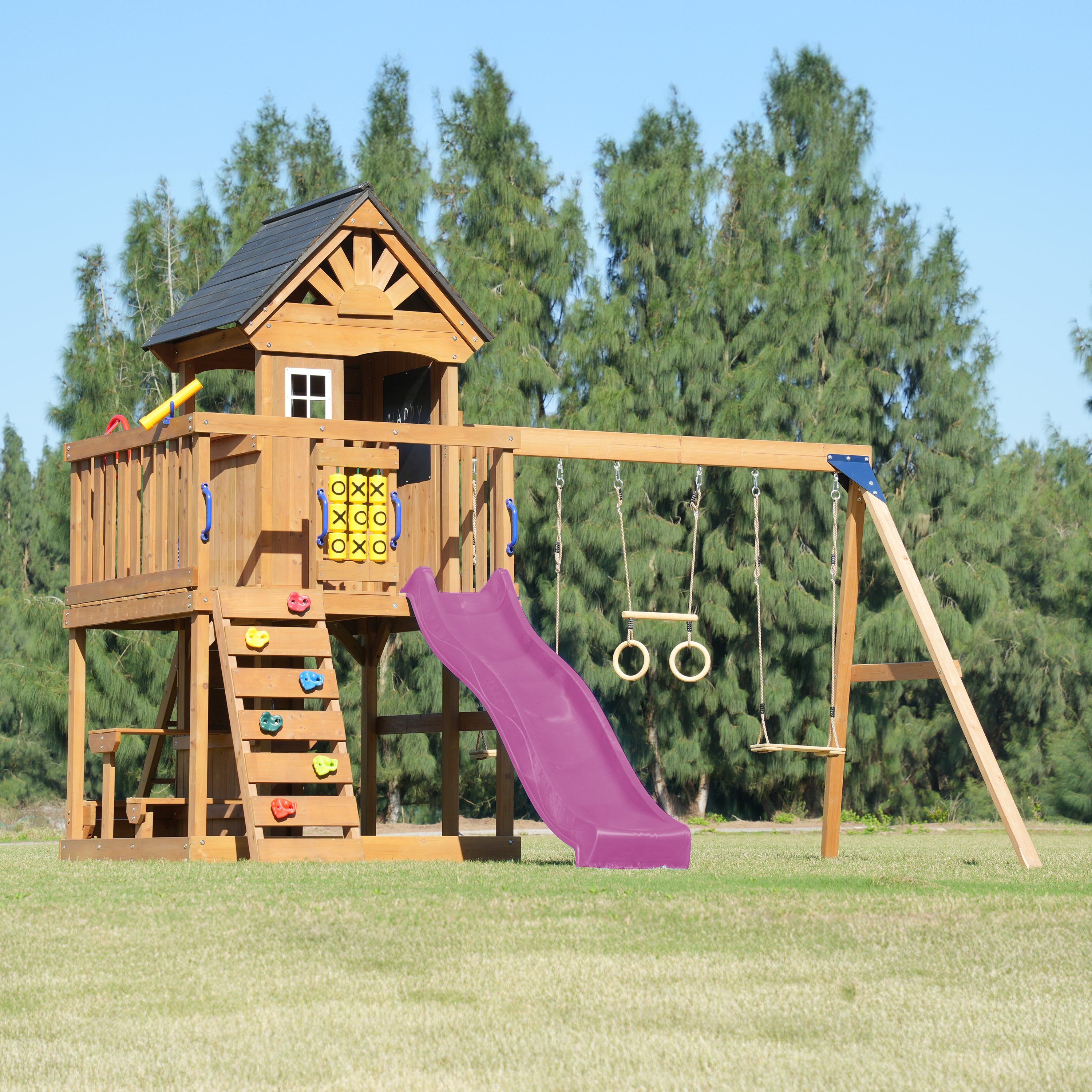 Ein hölzerner Spielturm mit Rutsche, Schaukeln und Kletterwand im Freien.