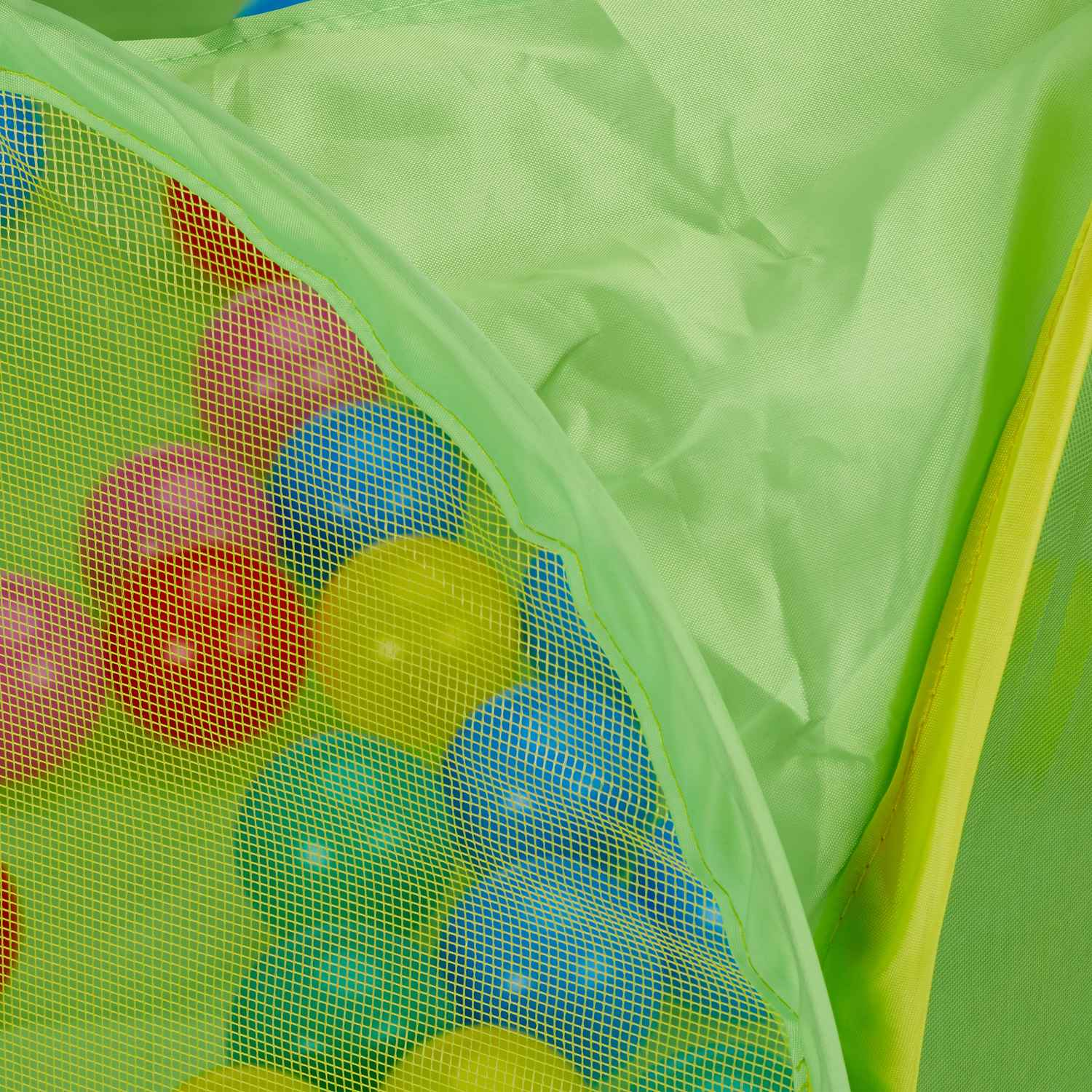 Bolas de colores dentro de una tienda de campaña de malla verde.