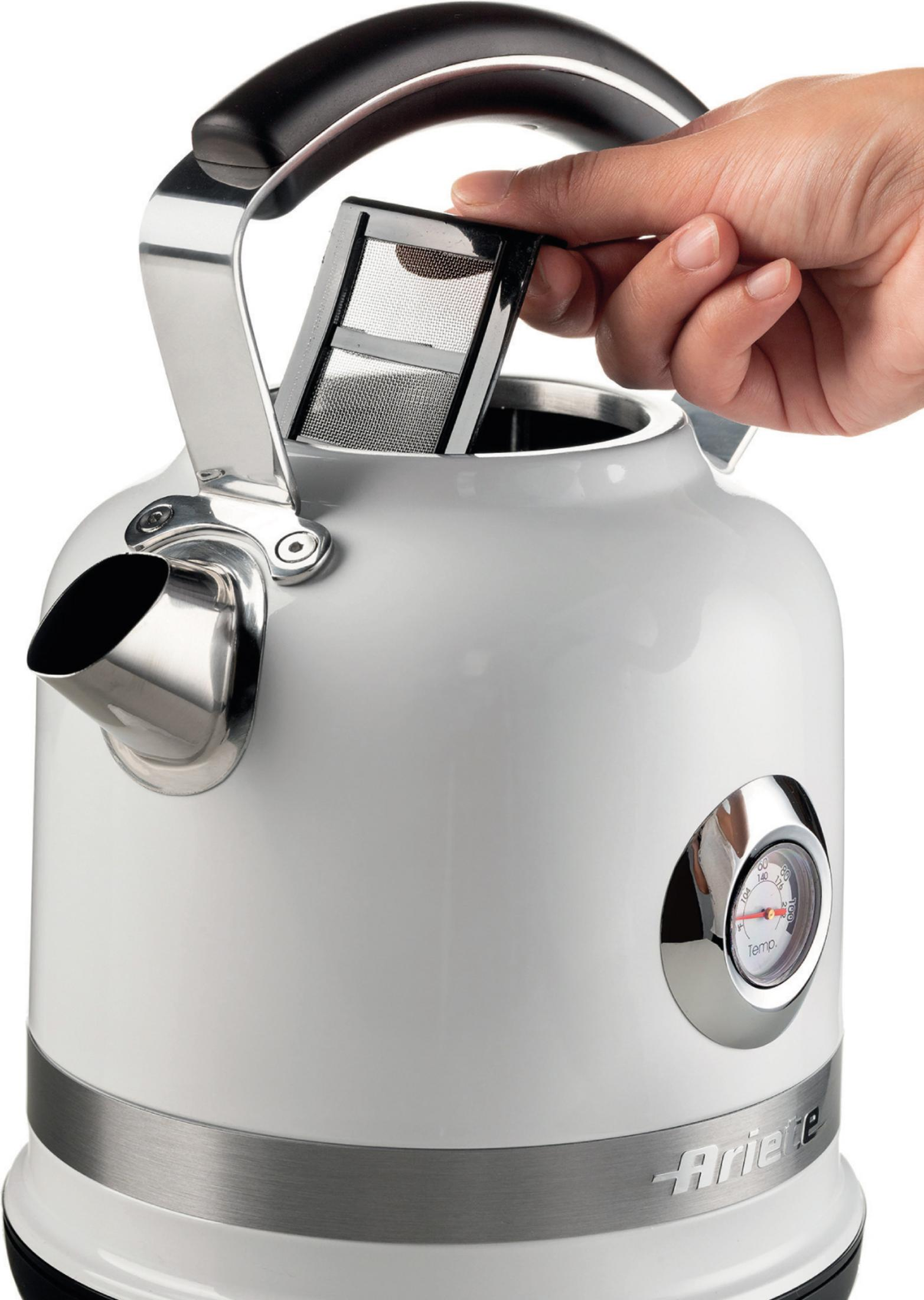 Ręka wkłada filtr do herbaty do białego czajnika z termometrem.