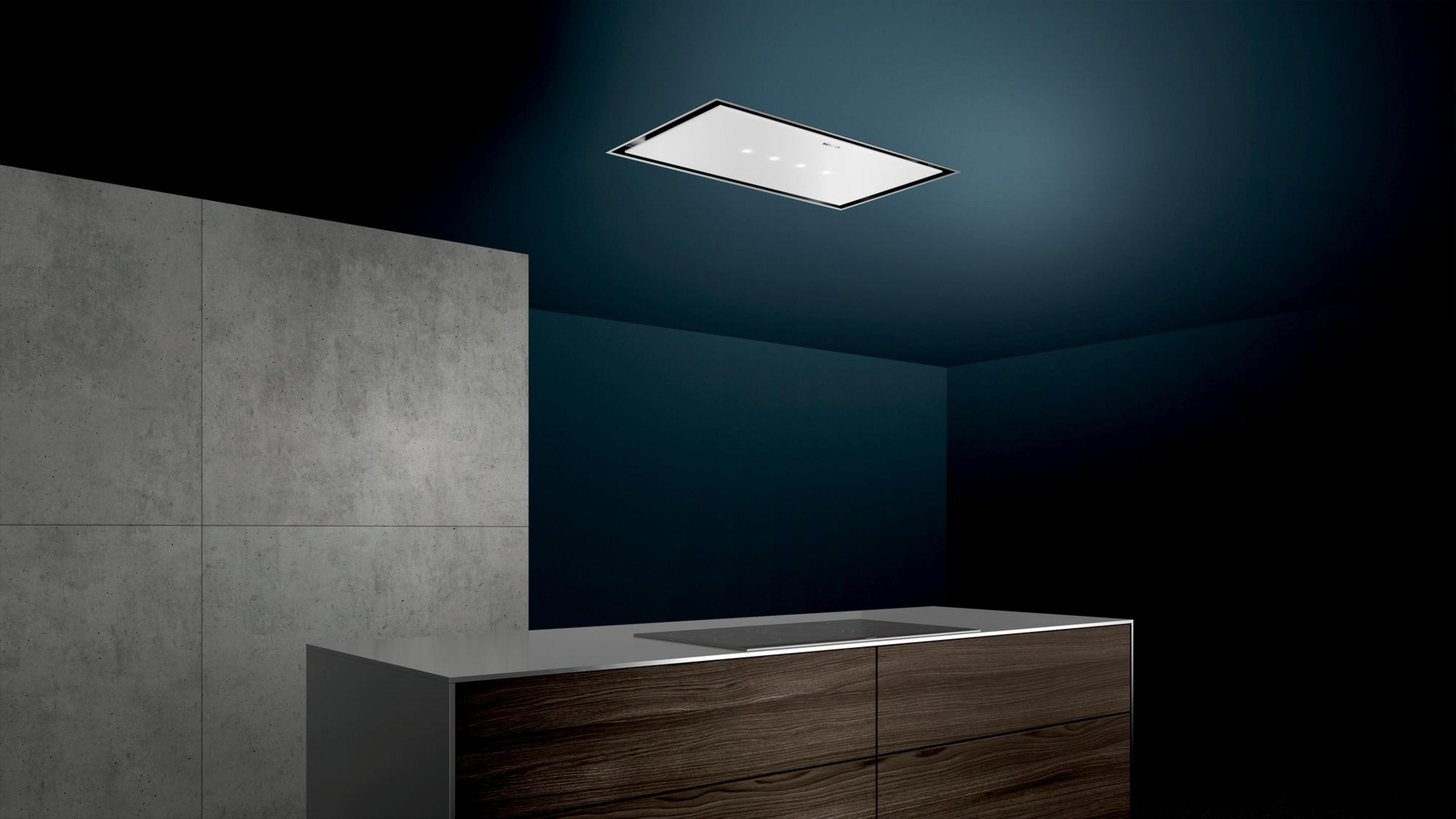 Modern kitchen with concrete wall, wood cabinets and ceiling extractor.