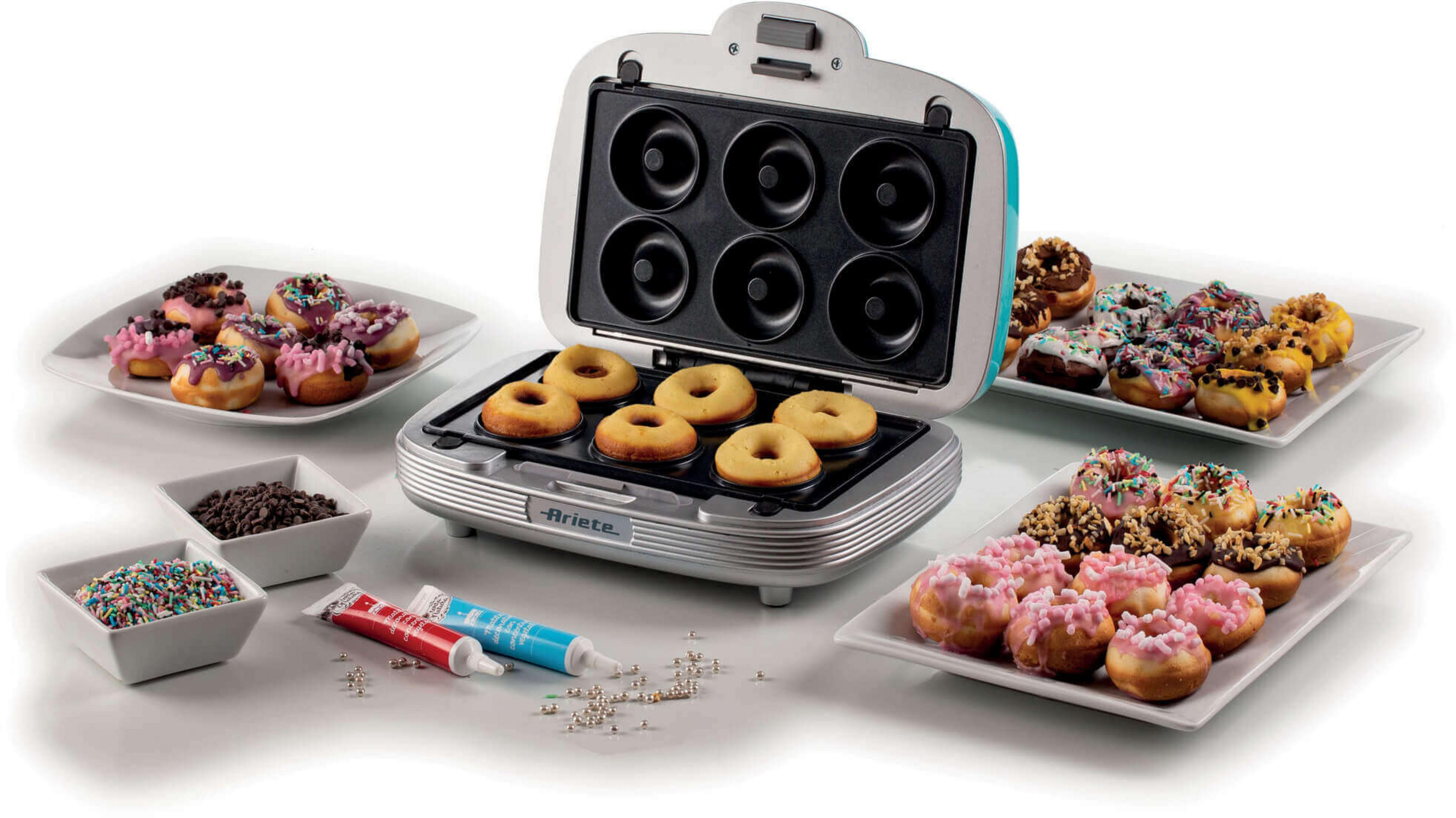 Maszyna do pączków z gotowymi i surowymi pączkami, posypkami i lukrem.