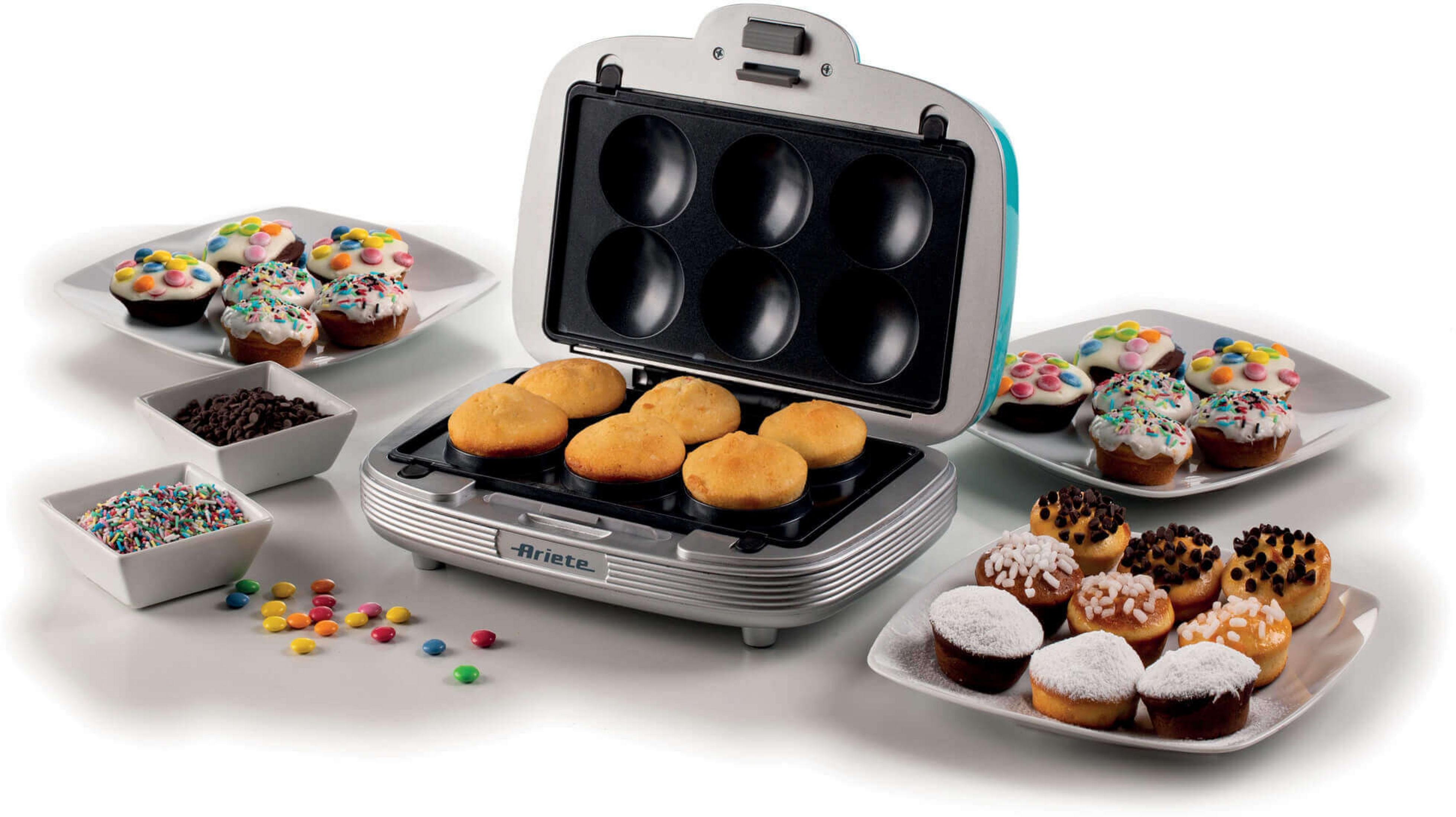 Otwarta mini maszyna do ciasta z upieczonymi ciastkami, lukrem i posypką.