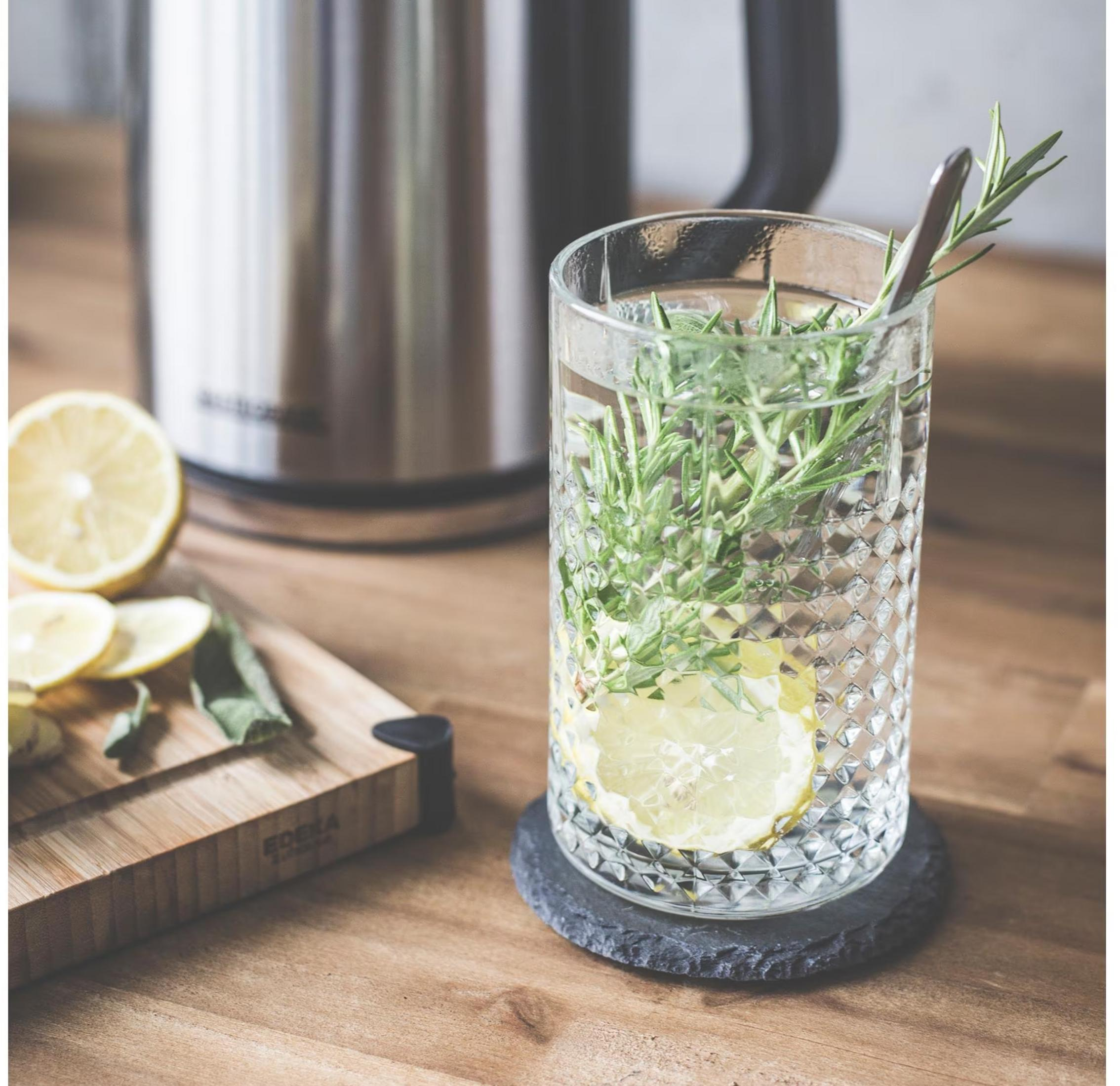 Ein Glas Wasser mit Zitrone und Rosmarin steht auf einem Untersetzer.
