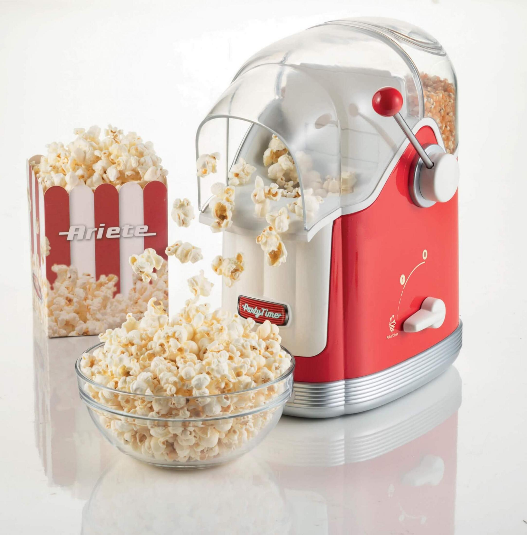 Rode popcornmachine met kom en doos vol popcorn.