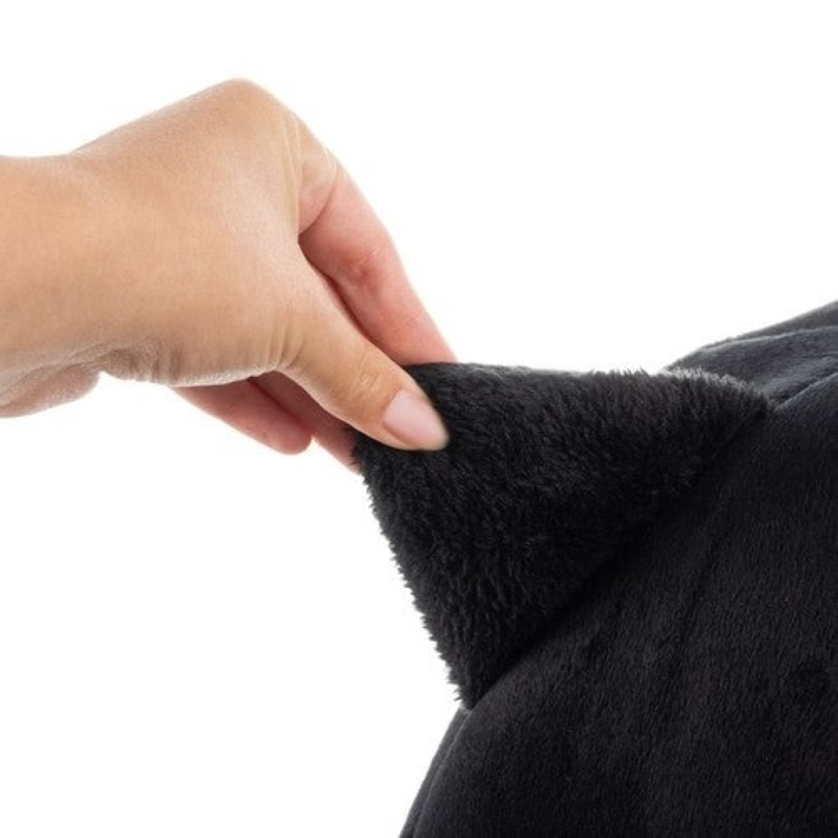 Una mano pellizca una oreja negra de peluche.