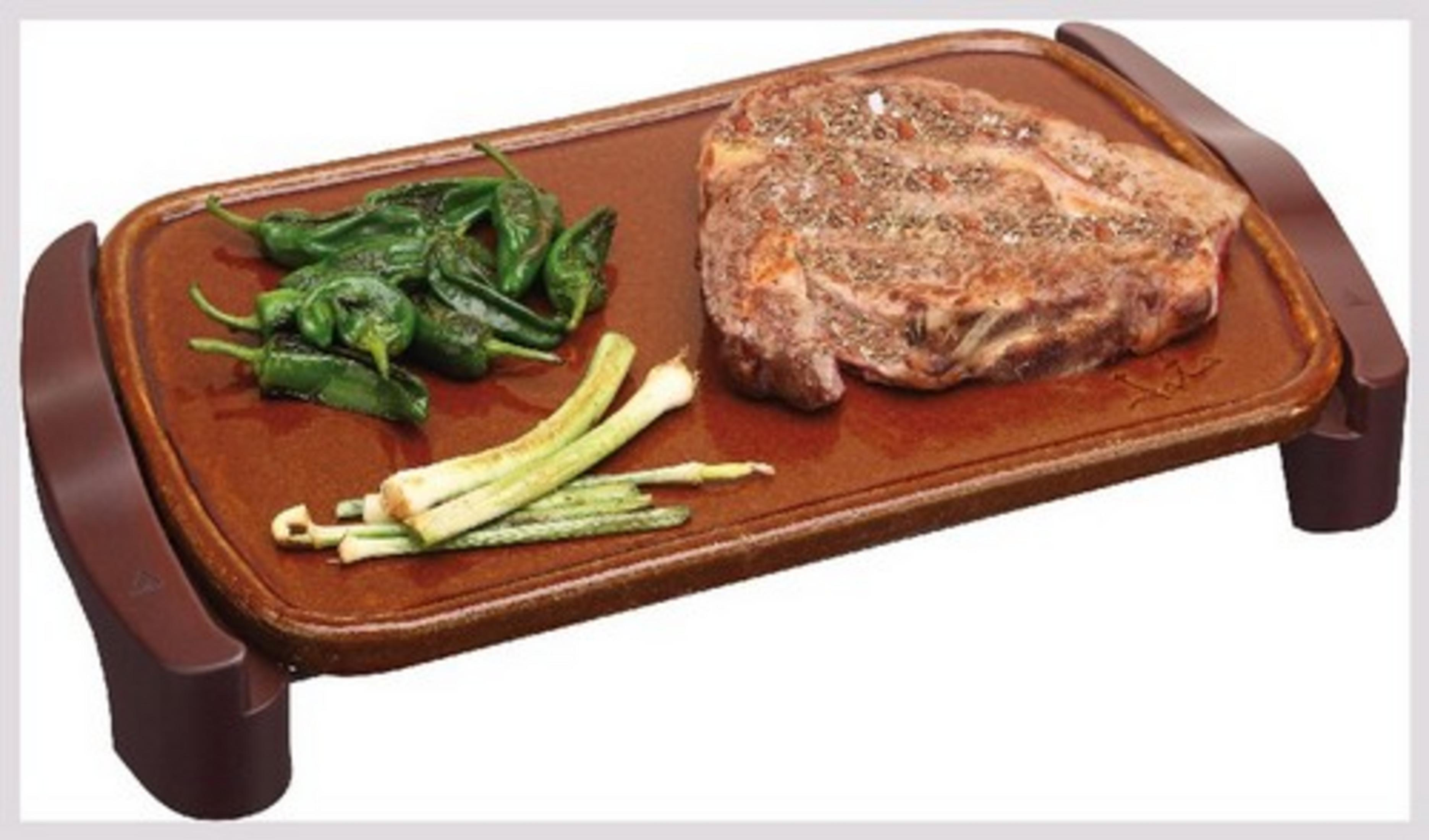 Un filete cocinado con pimientos verdes y cebolletas en una plancha.