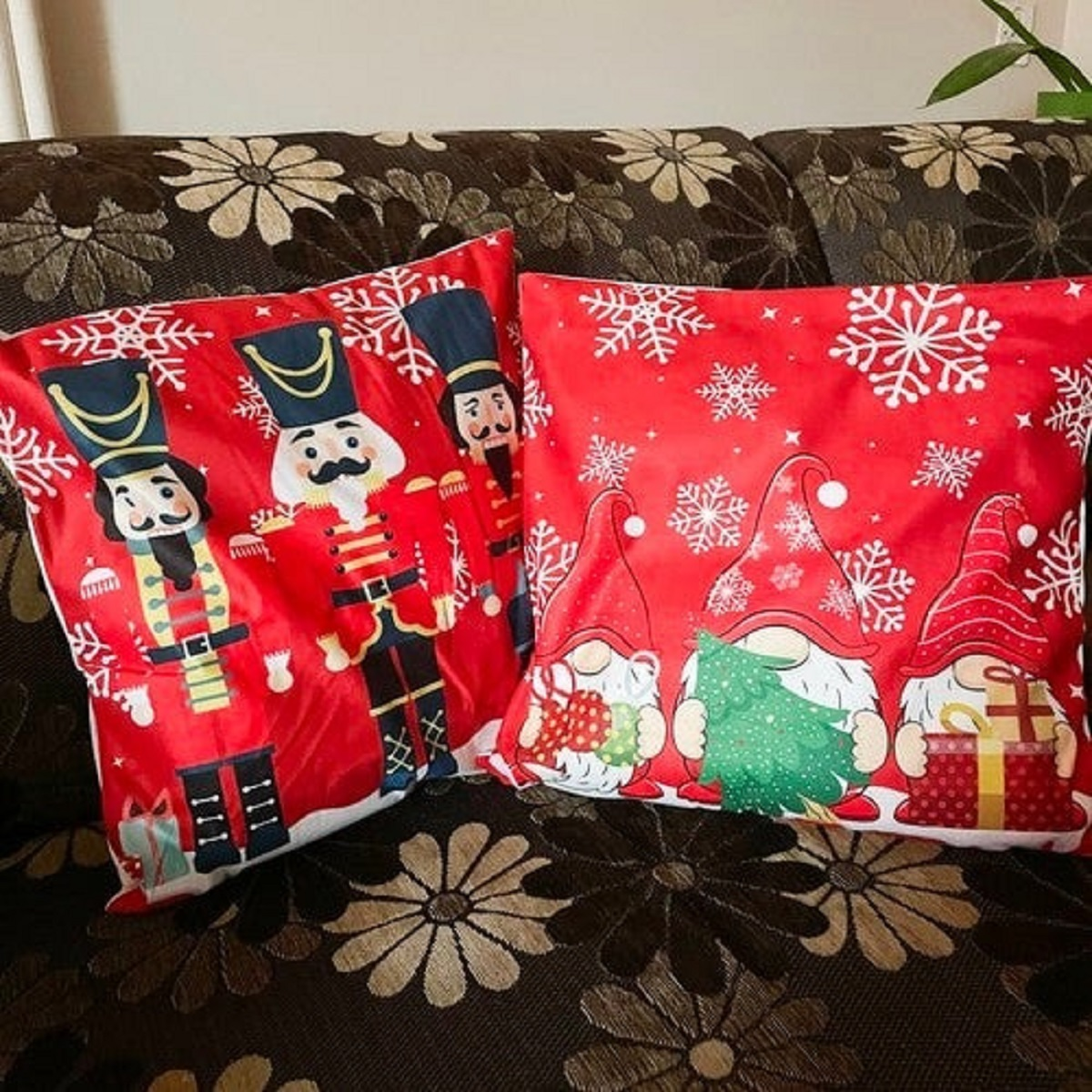 Dos cojines navideños: cascanueces y gnomos sobre fondo rojo.