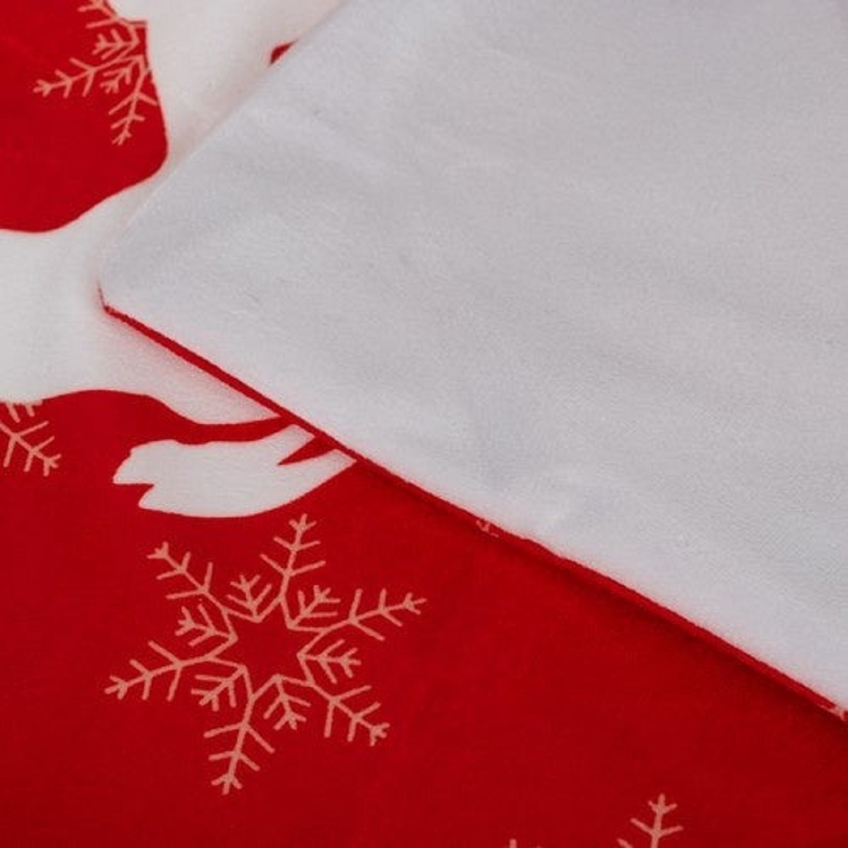 Tela roja con copos de nieve blancos y estampado de renos, con borde blanco.