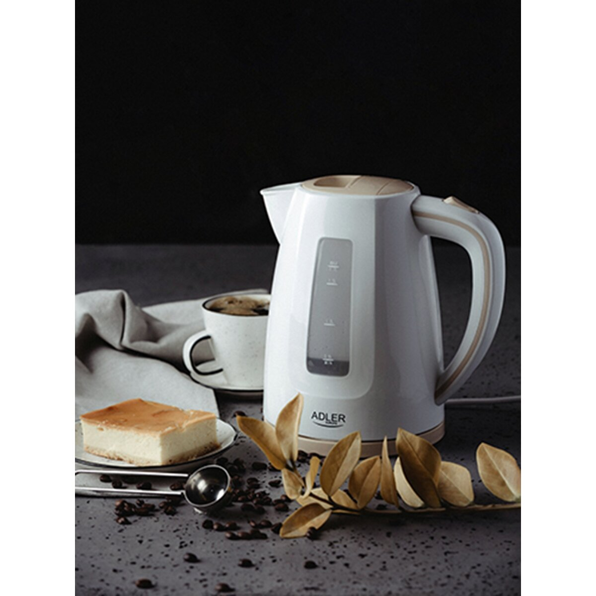Une bouilloire électrique blanche à côté d'une tasse de café et d'un gâteau.