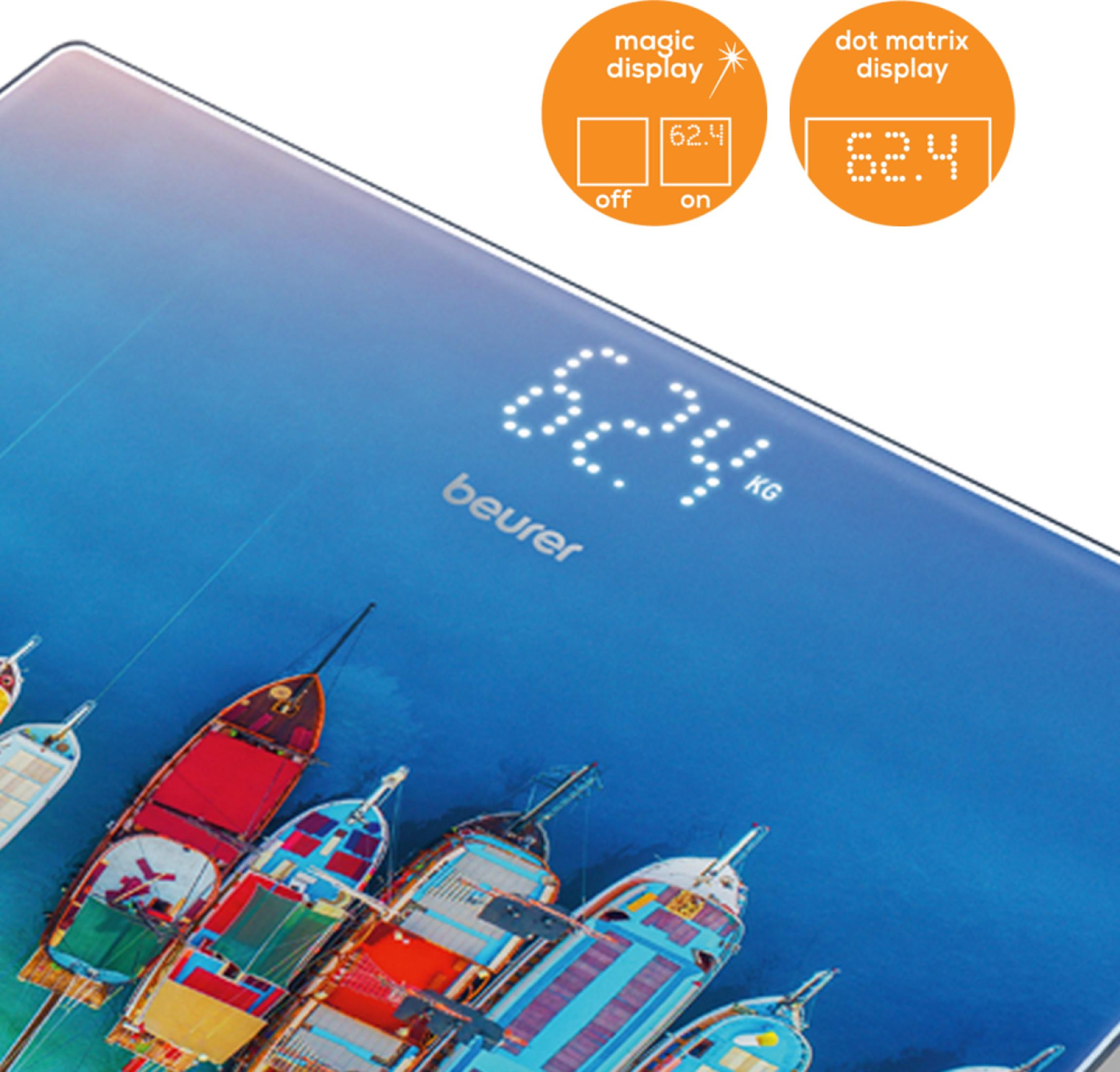 Une balance numérique affiche 62,4 kg, avec des bateaux en arrière-plan.