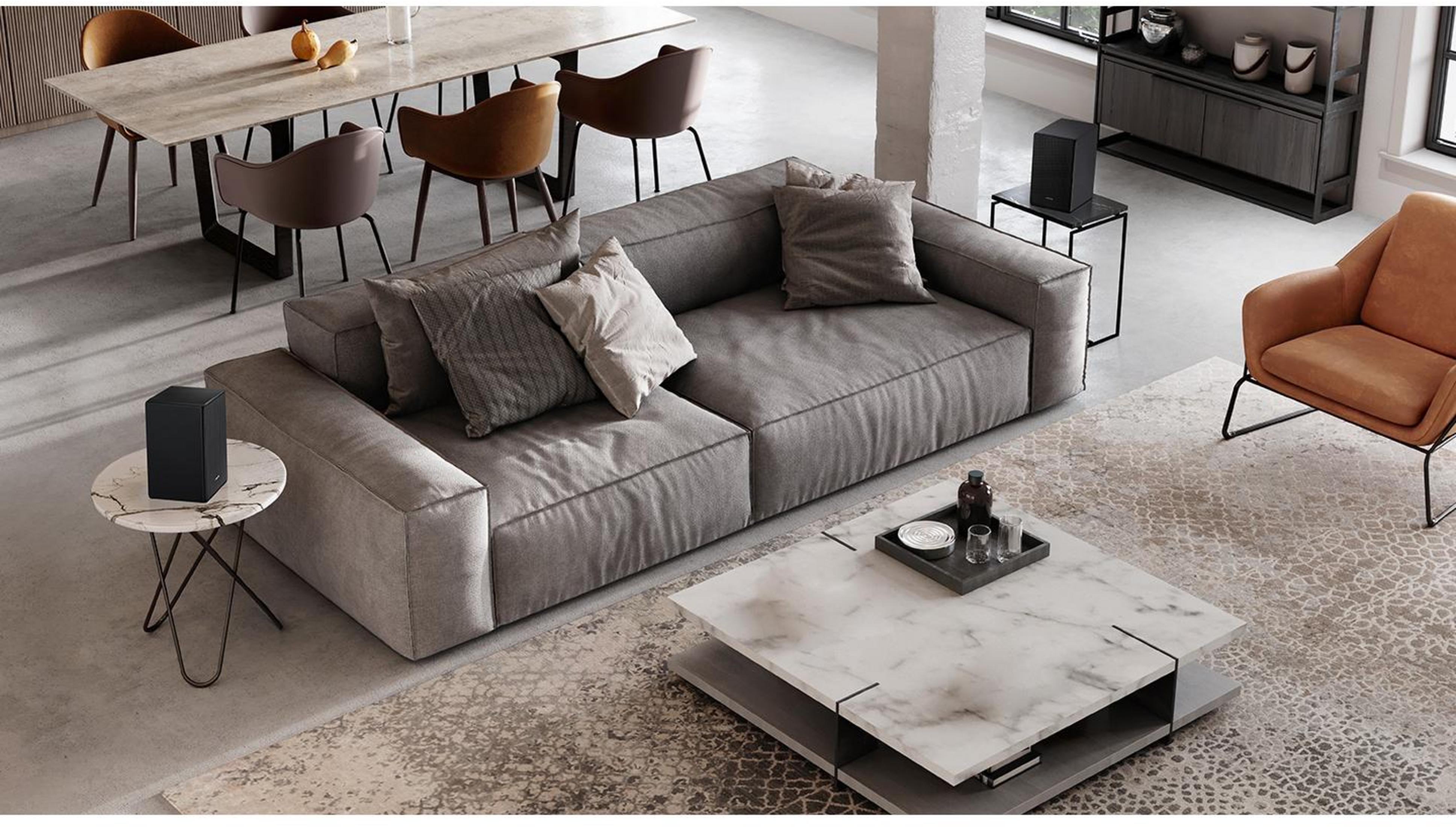 Graues Sofa mit Kissen, Marmortisch, brauner Sessel und Esstisch.