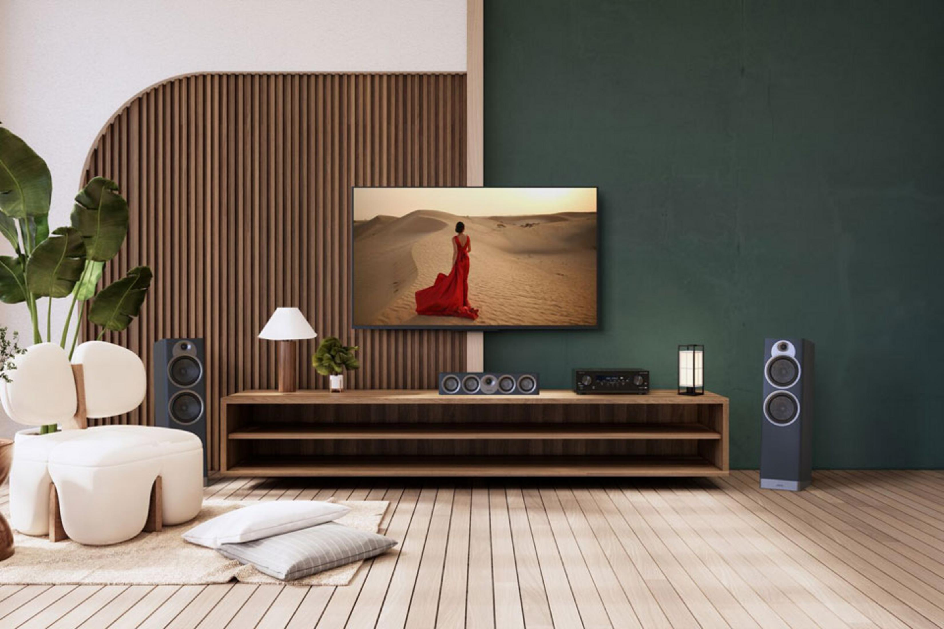 Ein Wohnzimmer mit einem Fernseher, der eine Frau in rotem Kleid in der Wüste zeigt.