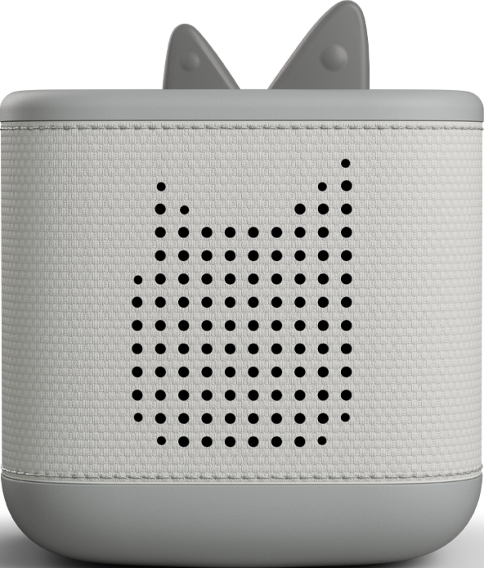 Un altavoz gris con orejas, sobre una cubierta de tela blanca.