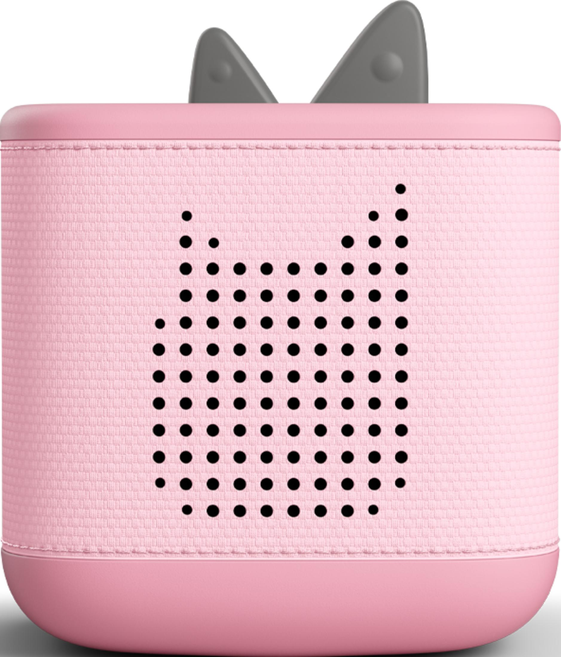 Une enceinte rose avec des points noirs formant un visage de chat ou d'animal.