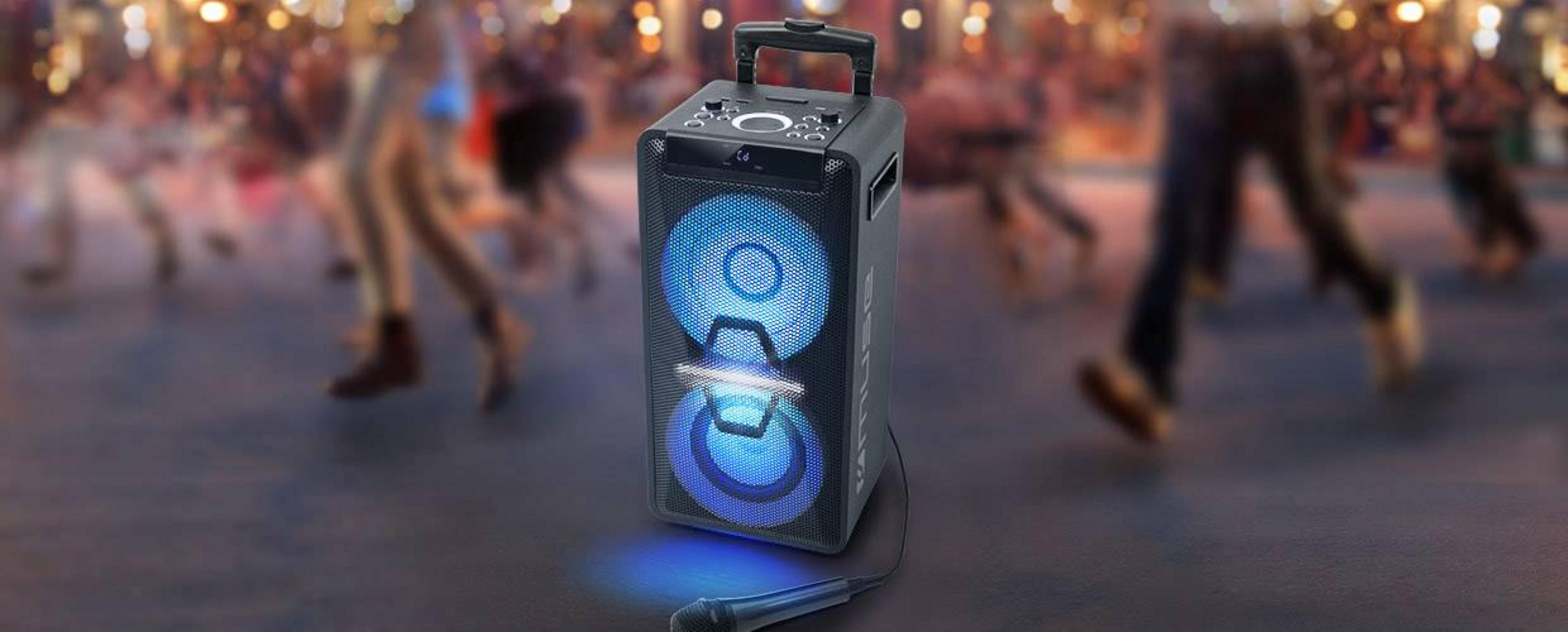 Un altavoz con luces azules delante de una multitud bailando.