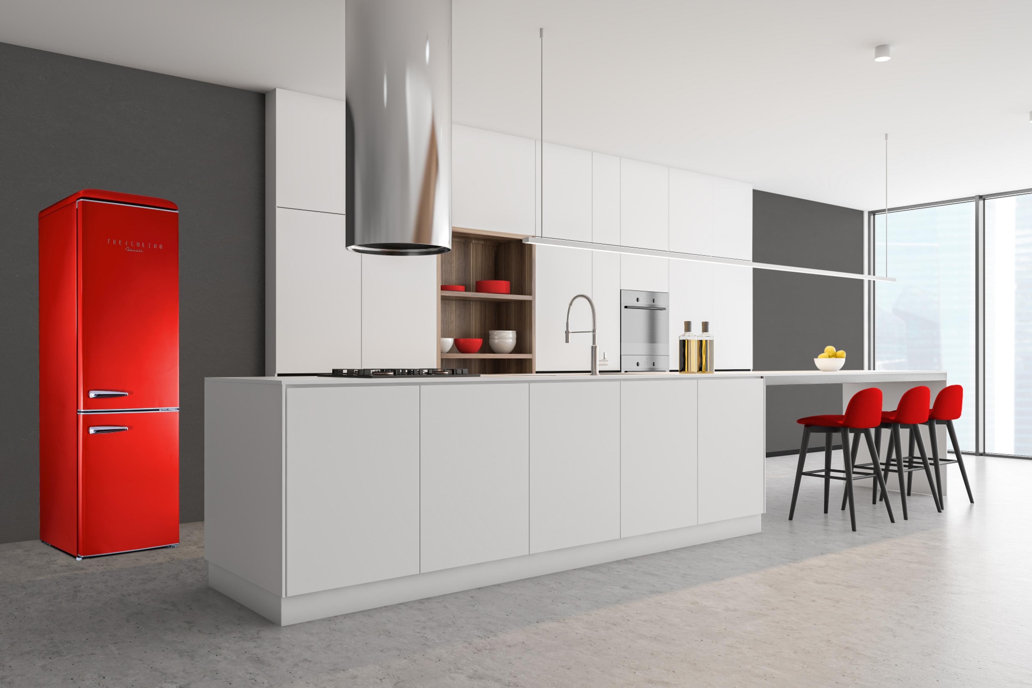Moderne Küche mit rotem Kühlschrank, weißen Schränken, Kochinsel und roten Barhockern.