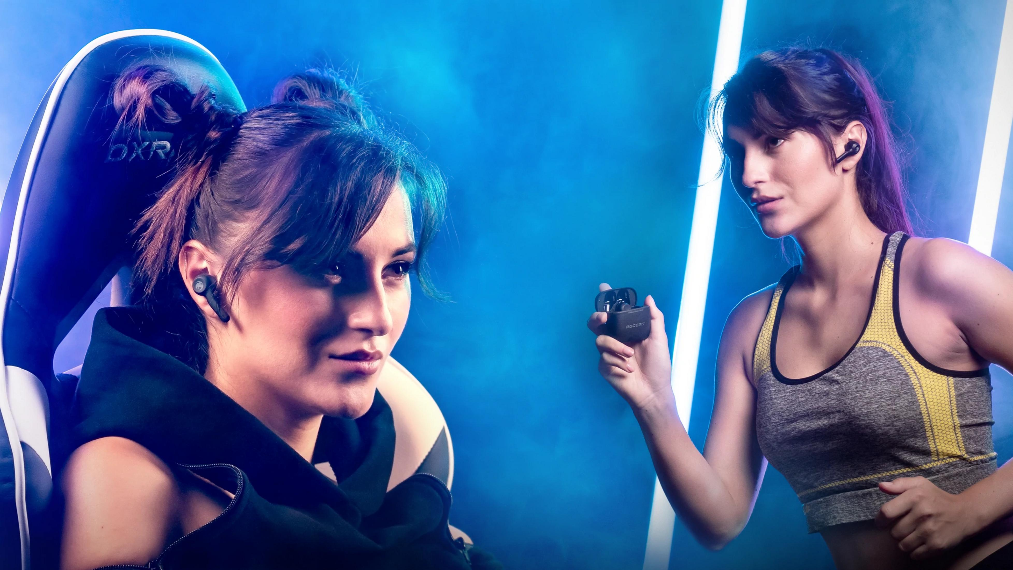 Due donne con auricolari, una in sedia da gaming, l'altra con top sportivo.