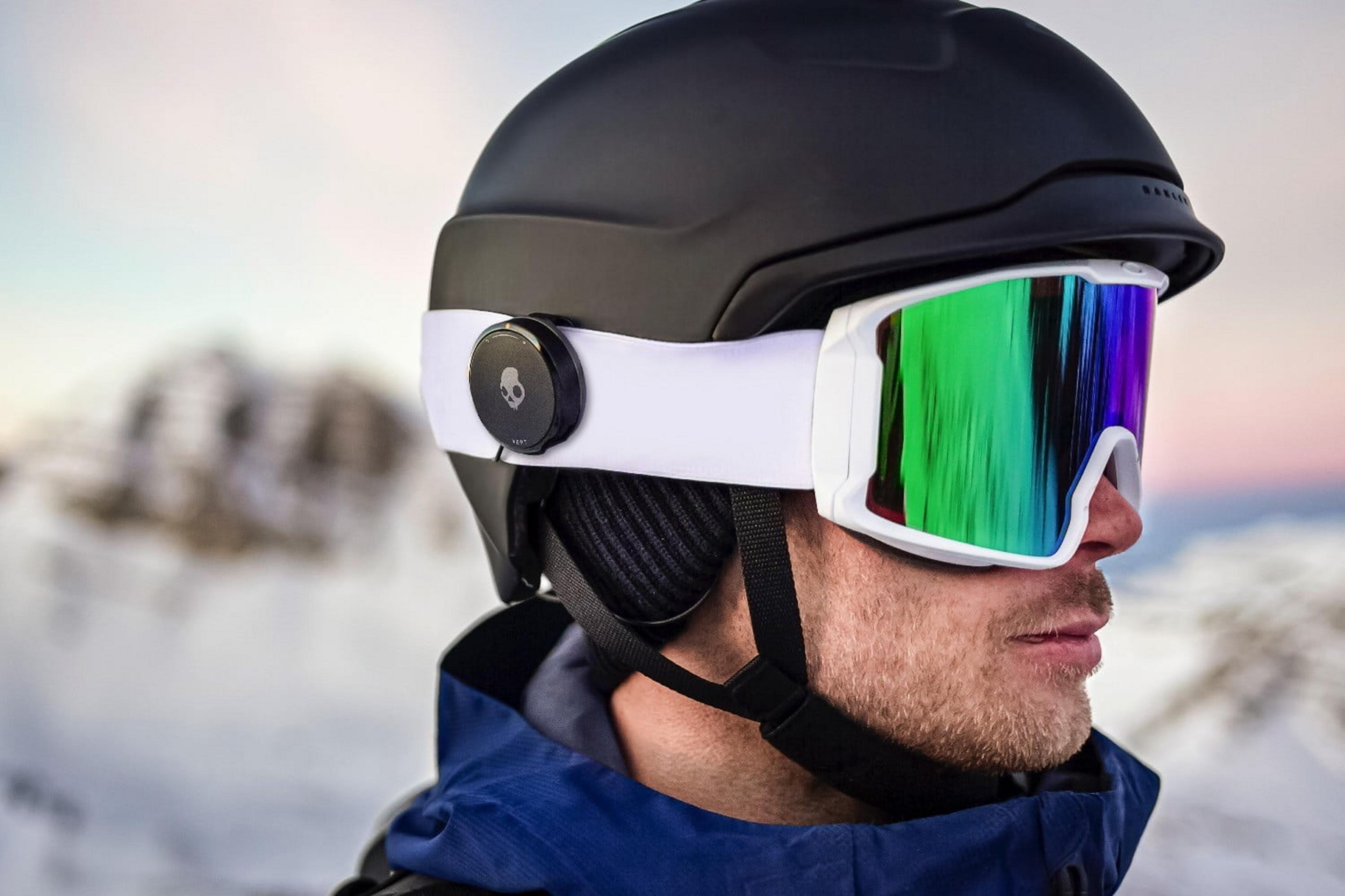 Uomo con casco e maschera da sci in montagna innevata.