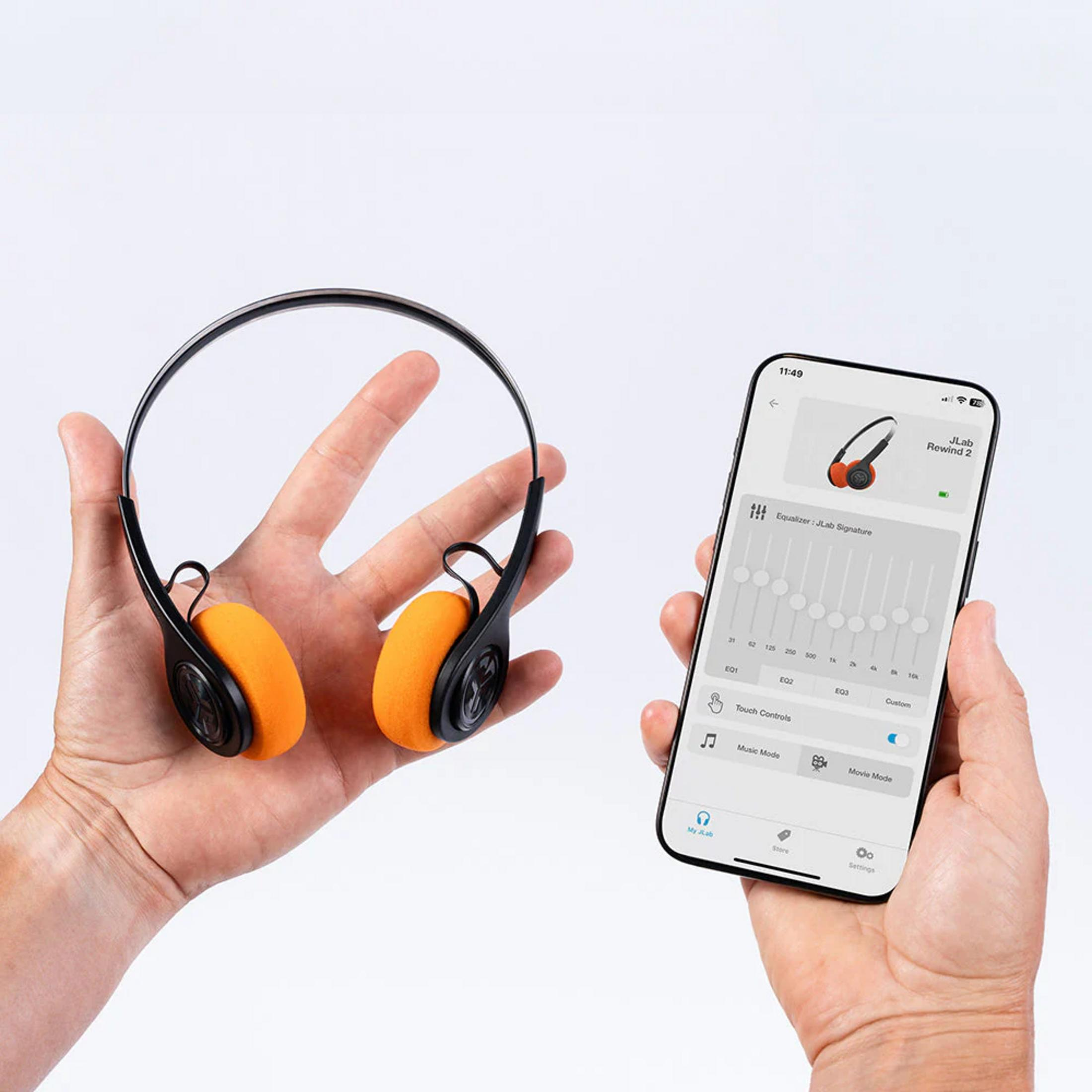 Hände halten orange JLab Rewind 2 Kopfhörer und ein Smartphone mit Equalizer-App.