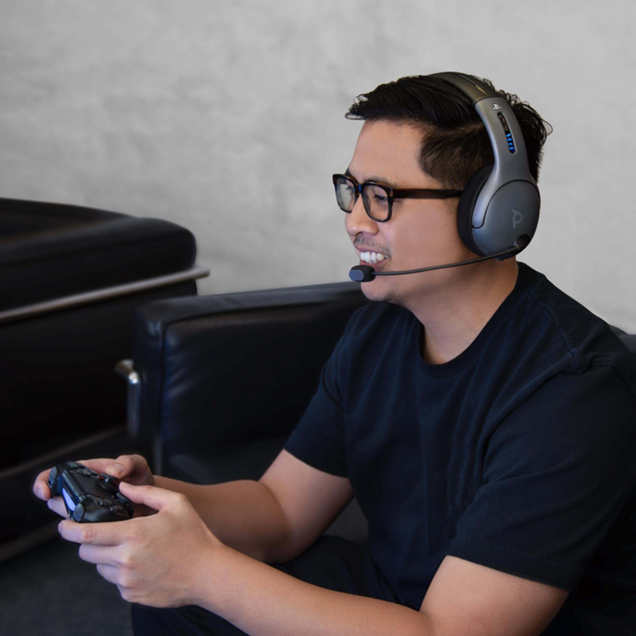 Mężczyzna w okularach i zestawie słuchawkowym gra kontrolerem.