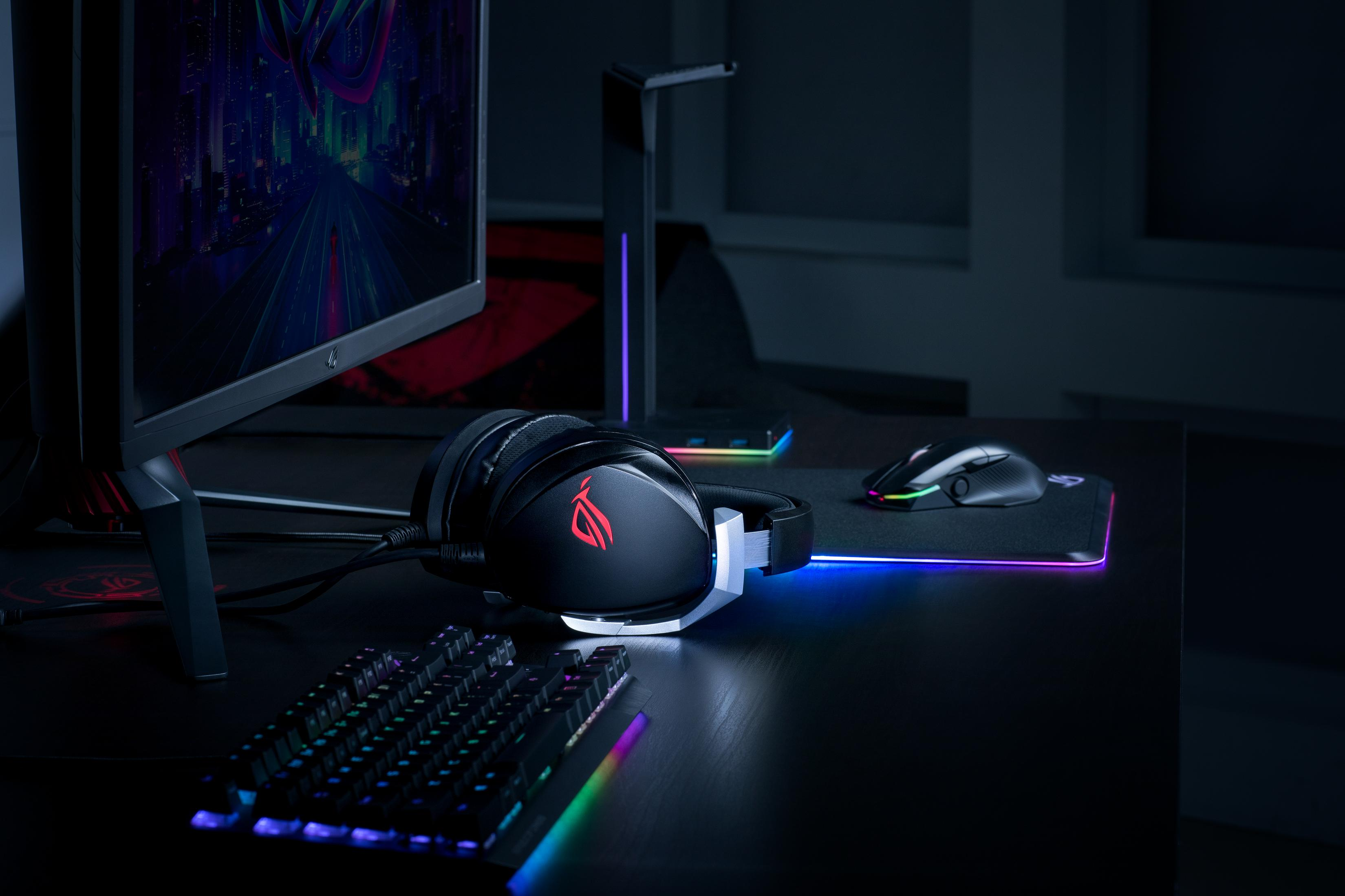 Schwarzer Gaming-Schreibtisch mit leuchtenden Kopfhörern, Tastatur und Maus.