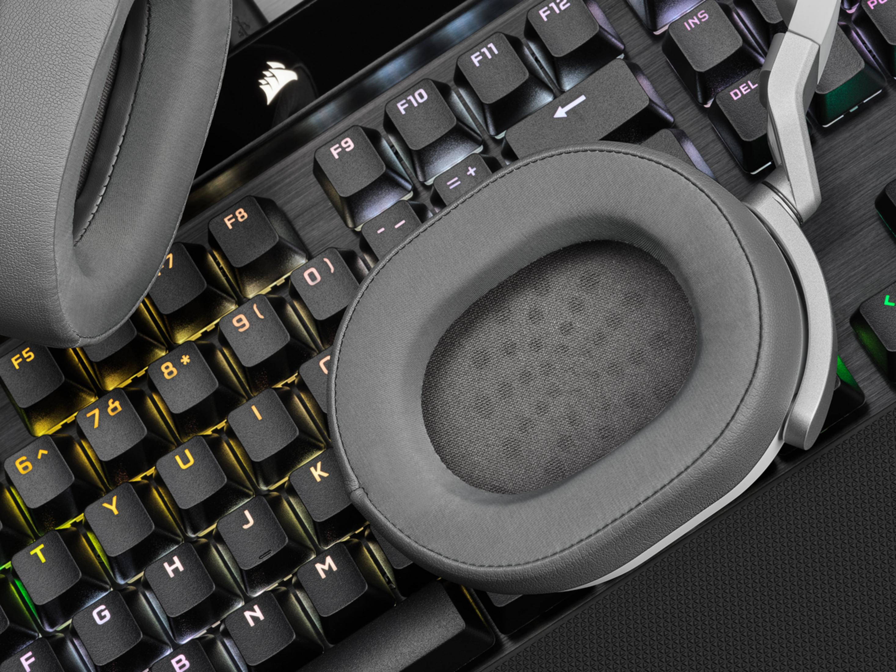 Szare słuchawki na podświetlanej klawiaturze. Widok z bliska.