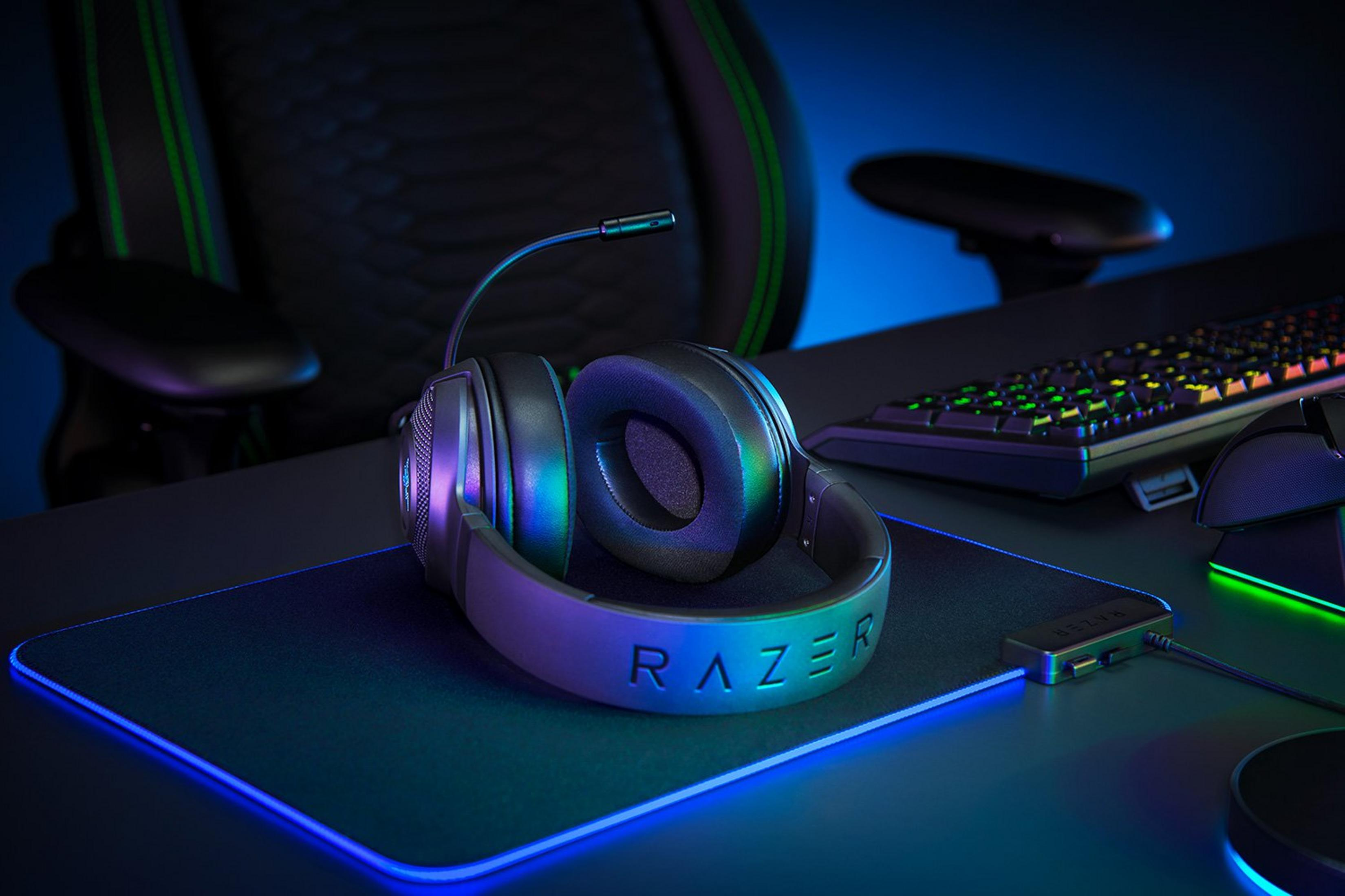 Un headset Razer con microfono poggia su un tappetino per mouse illuminato di blu.