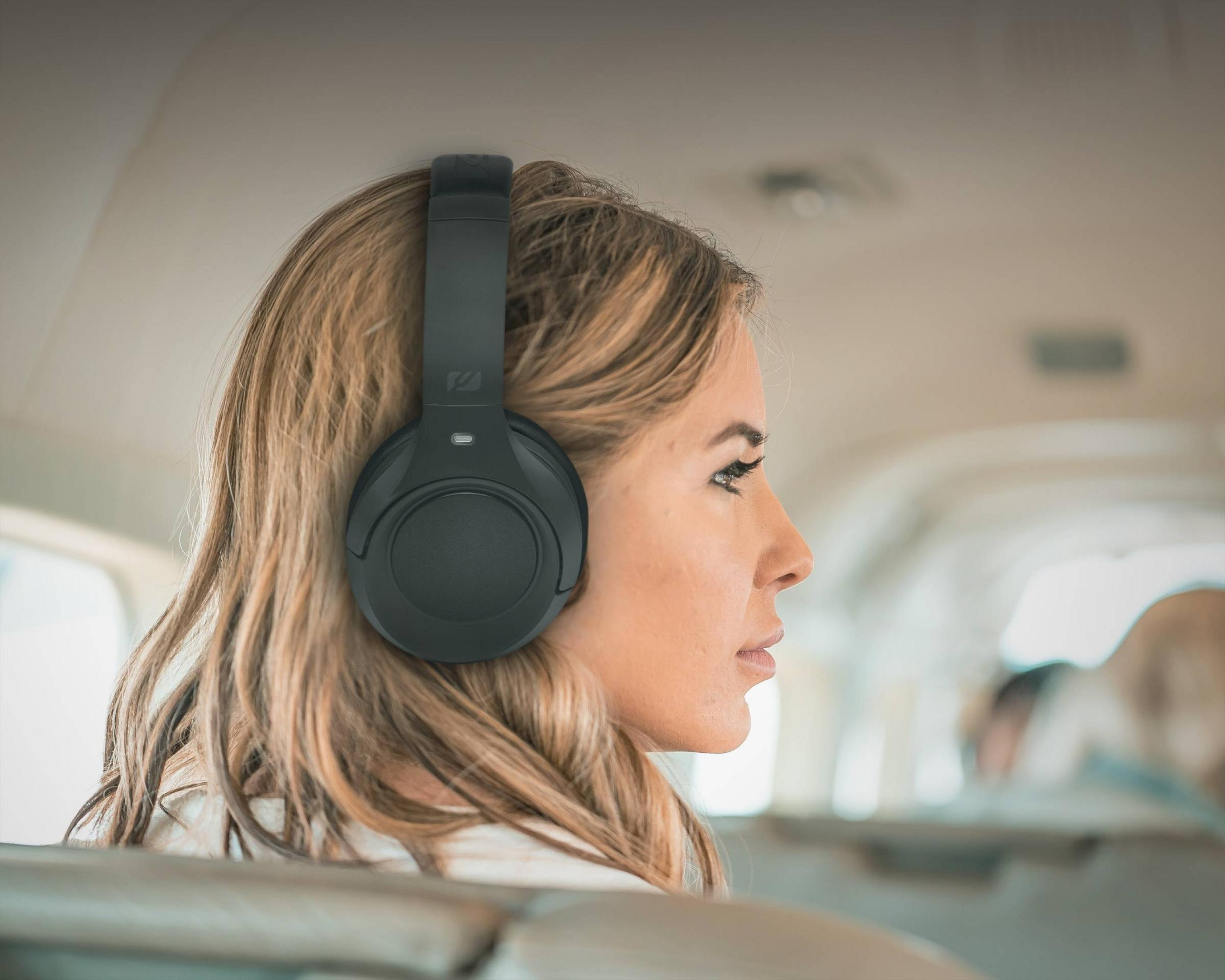 Une femme portant un casque dans un avion, vue de profil.