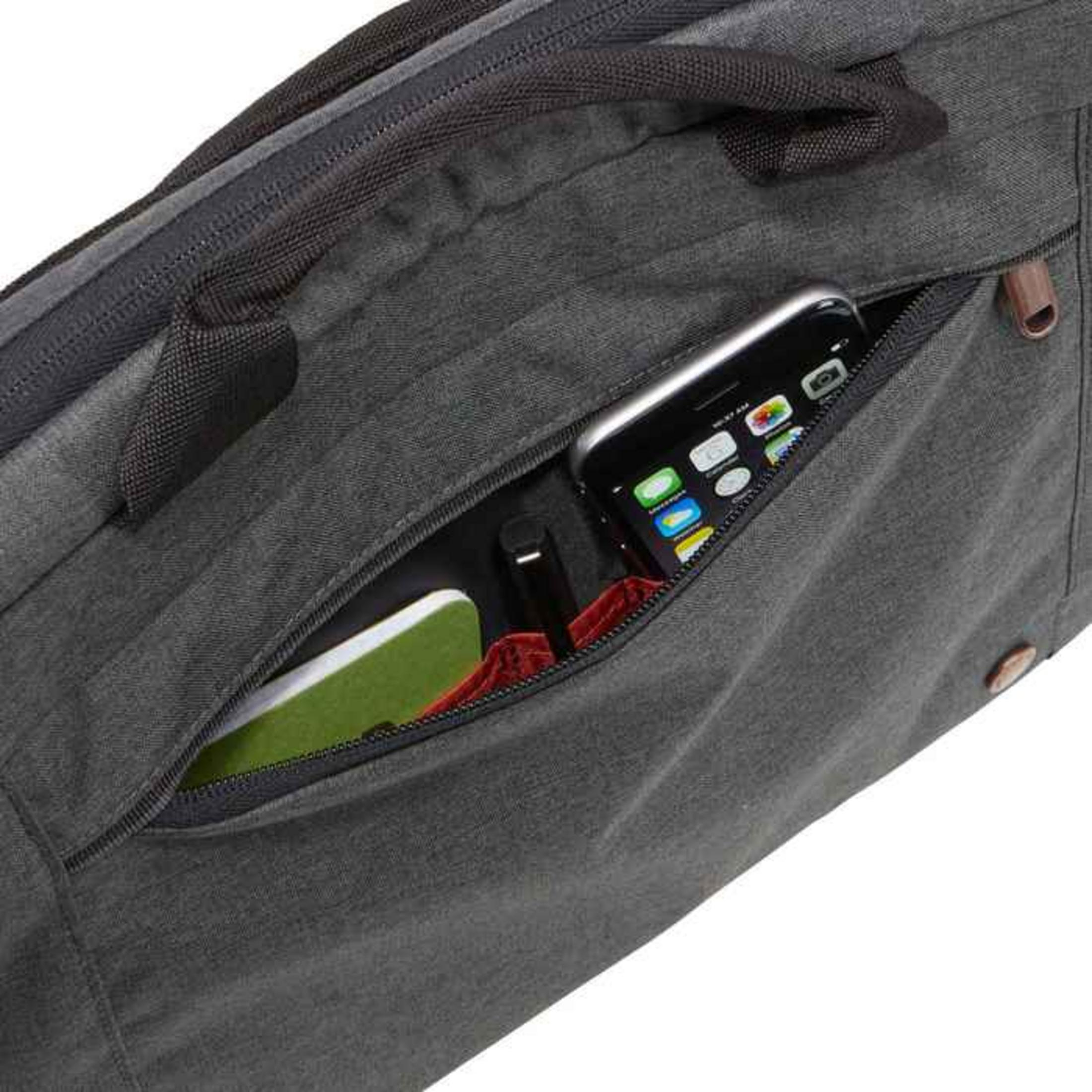 Een grijze tas met een open vak met daarin een telefoon en een notitieboekje.
