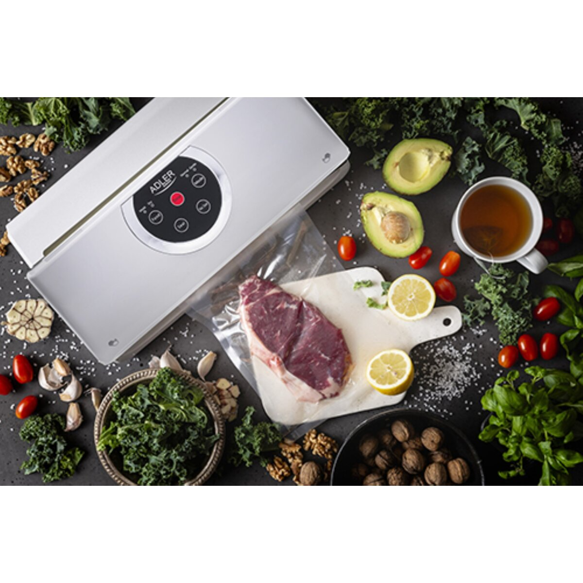 Urządzenie do pakowania próżniowego zamyka stek obok składników takich jak awokado, pomidory i orzechy.