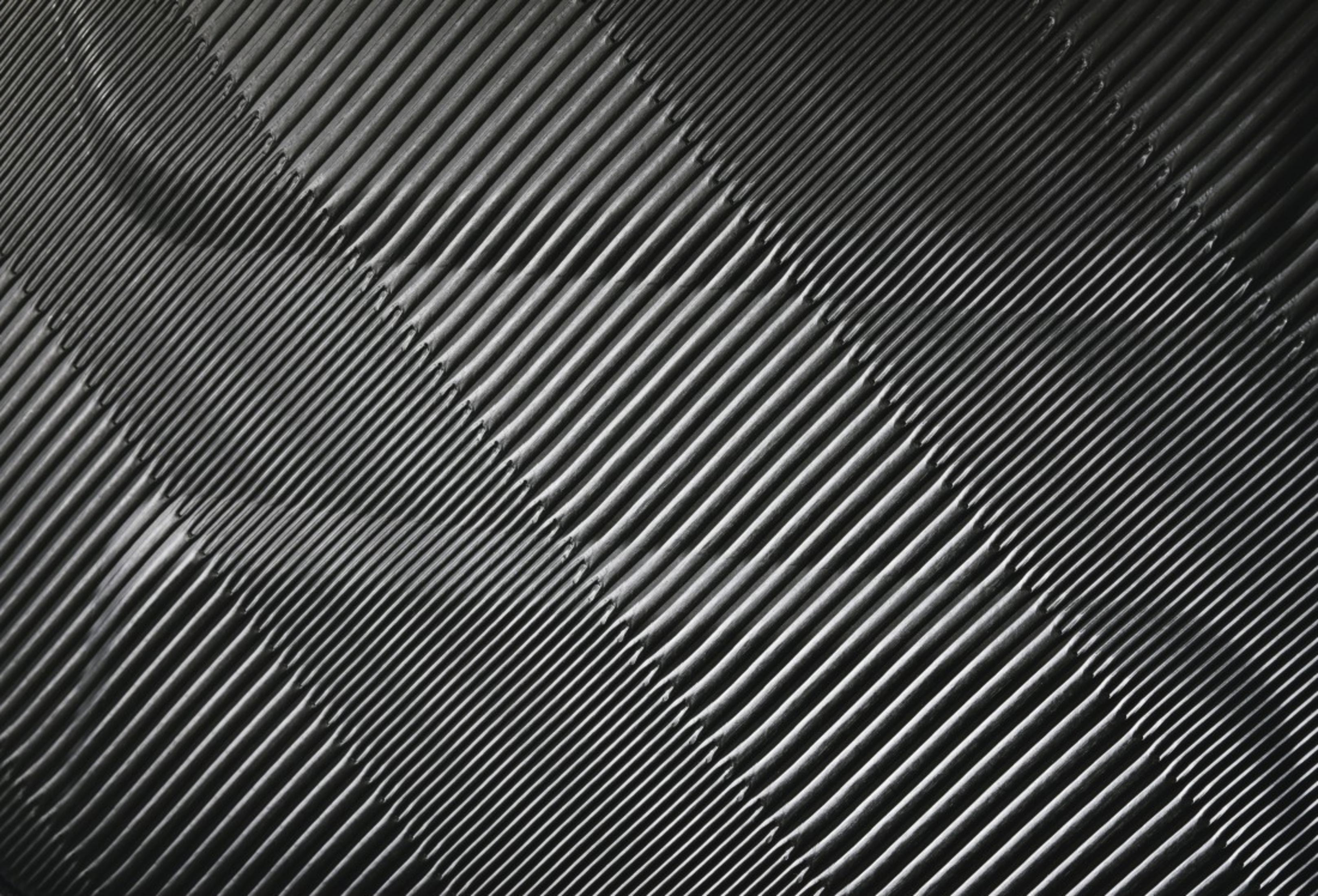 Dunkle, parallele Linien, die sich diagonal über das Bild erstrecken, mit Schatten.