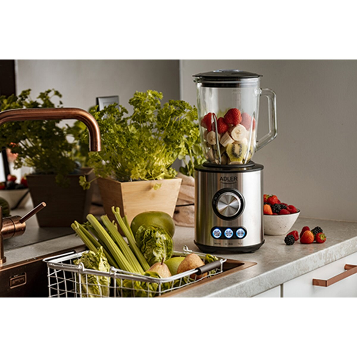 Blender z owocami i warzywami na blacie. Jagody i sałata w pobliżu.