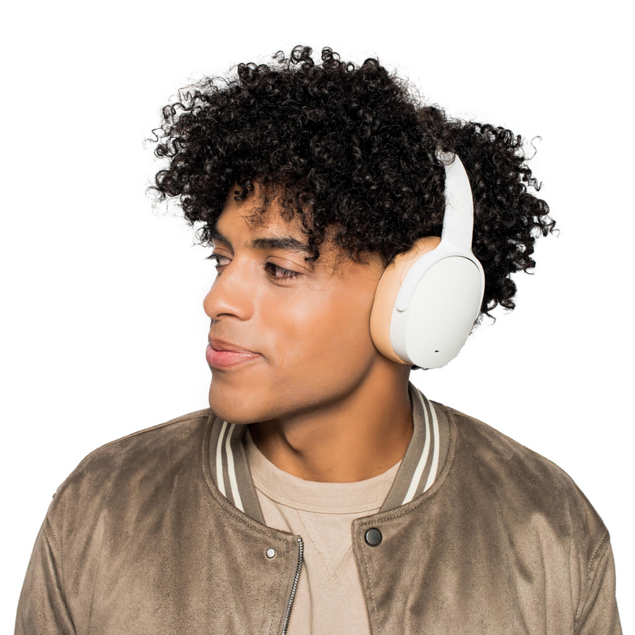 Mężczyzna z kręconymi włosami w białych słuchawkach na białym tle.