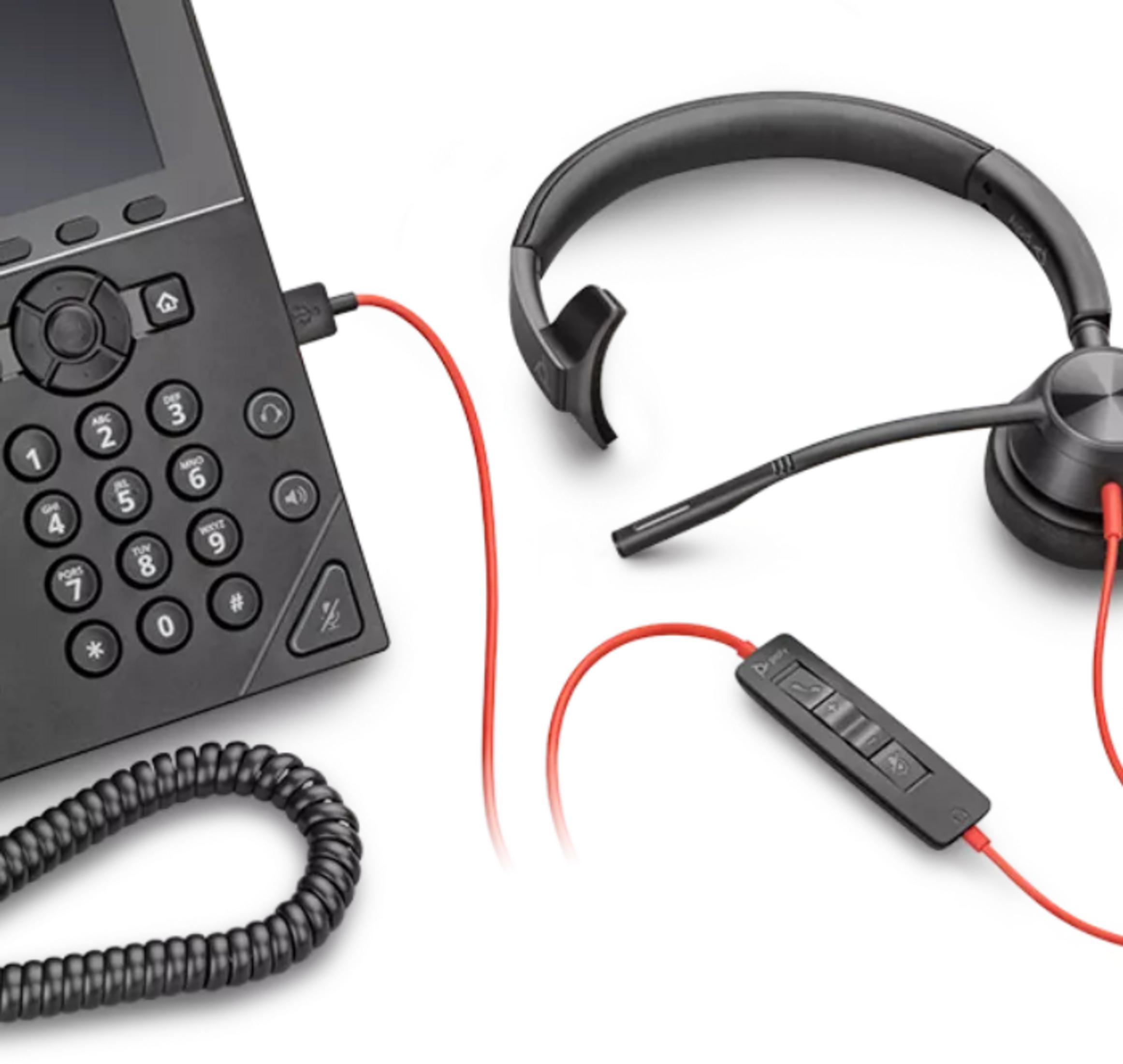 Czarny zestaw słuchawkowy z czerwonym kablem jest podłączony do telefonu biurowego.