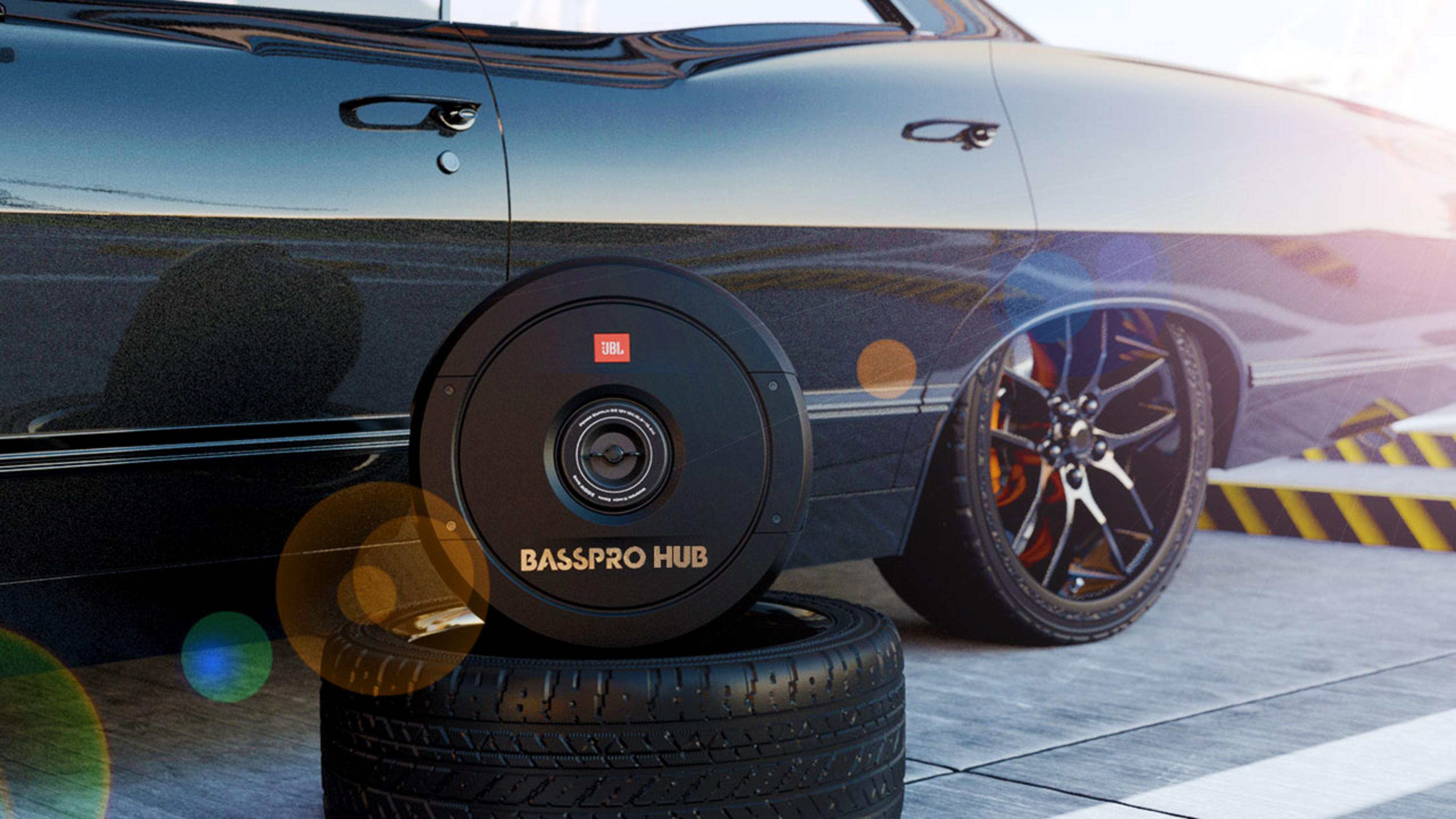 Auto nera con JBL Basspro Hub su pneumatici, cerchi accattivanti, riflessi.