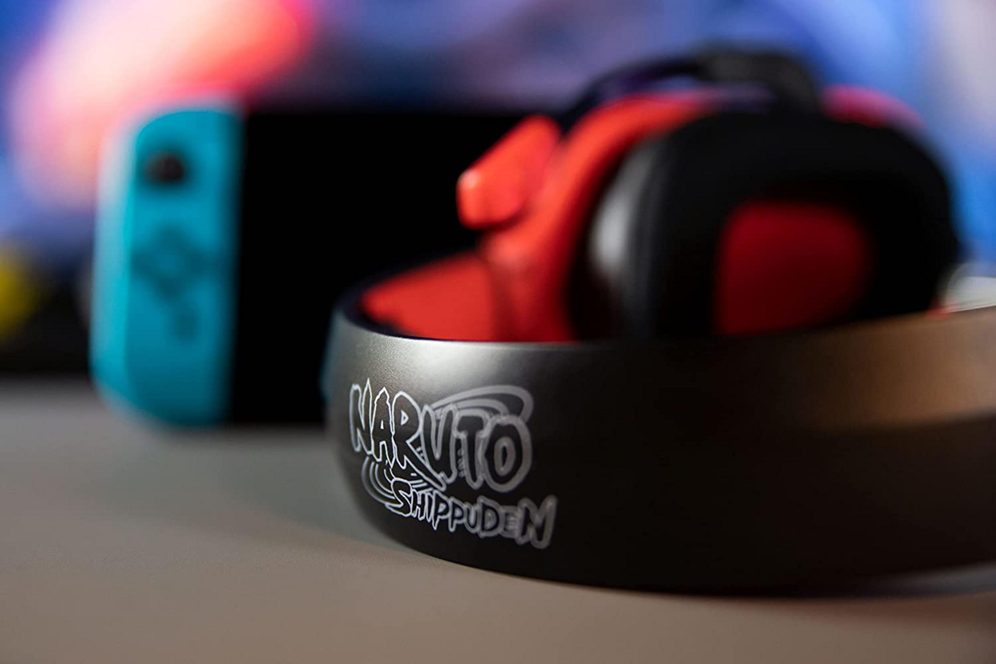 Cuffie rosse con logo Naruto Shippuden accanto a una Nintendo Switch blu.