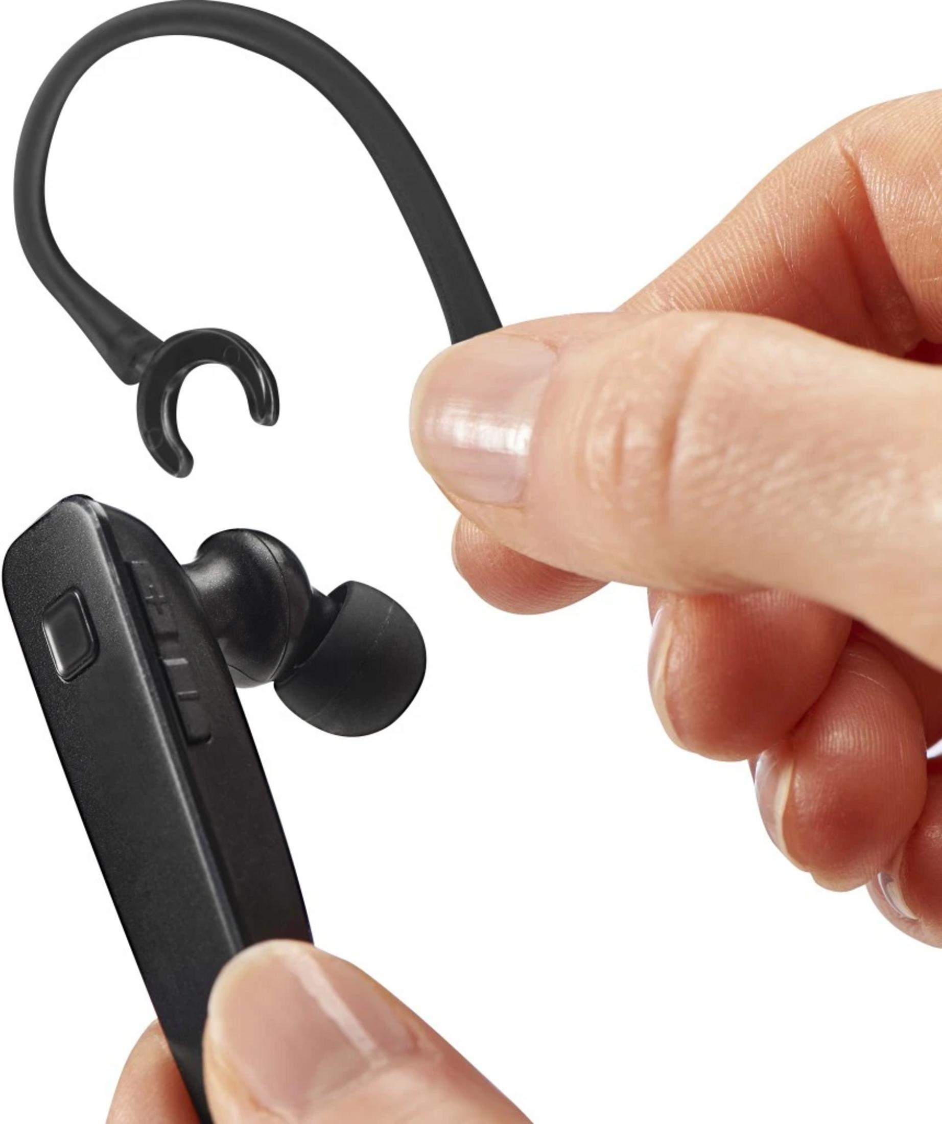 Ręka trzyma czarny zestaw słuchawkowy Bluetooth z zaczepem na ucho.